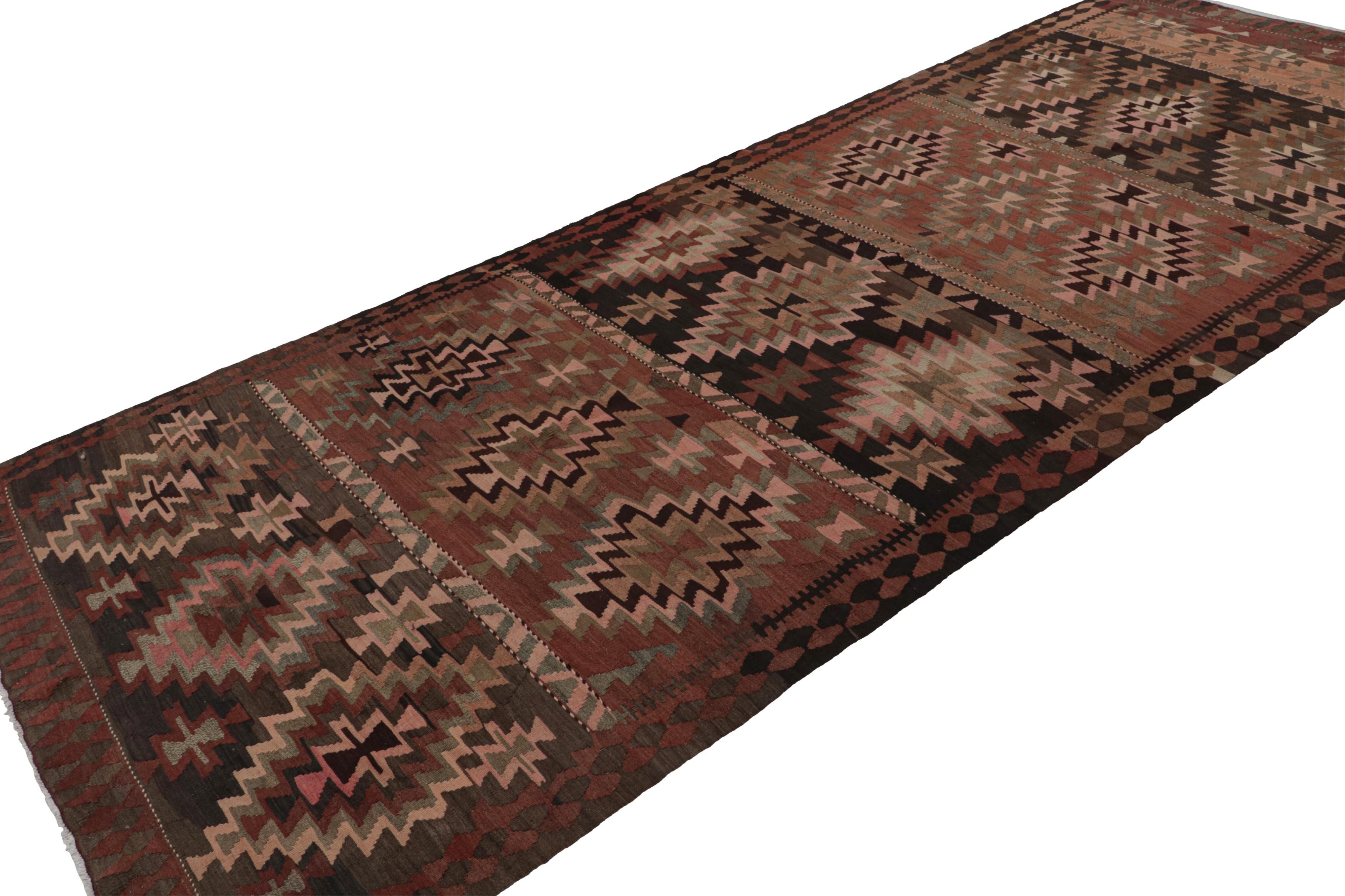 Handwoven in wool, circa 1950-1960, this 6x14 vintage Afghan tribal kilim and gallery runner rug features a minimal palette of rich brown and pink colors and vibrant rust and green accents. 

On the design: 

Connoisseurs will appreciate this rug as