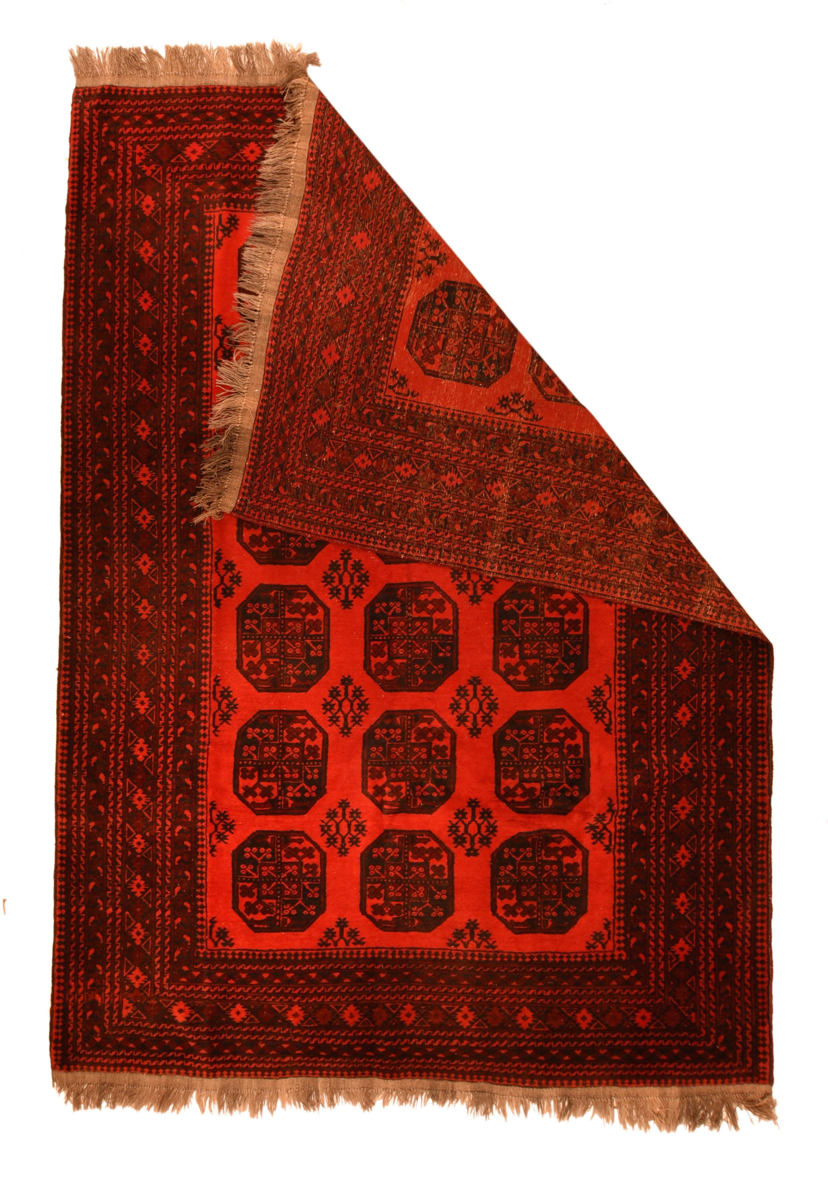Tappeto afgano vintage 6'6'' x 9'1''. Il campo scarlatto mostra tre colonne di sei gul turkmeni ottagonali inquartati con gul secondari a reticolo di stelle sagdak. Numerosi bordi a S centrati su una striscia nero-marino con asiks e triangoli. Base