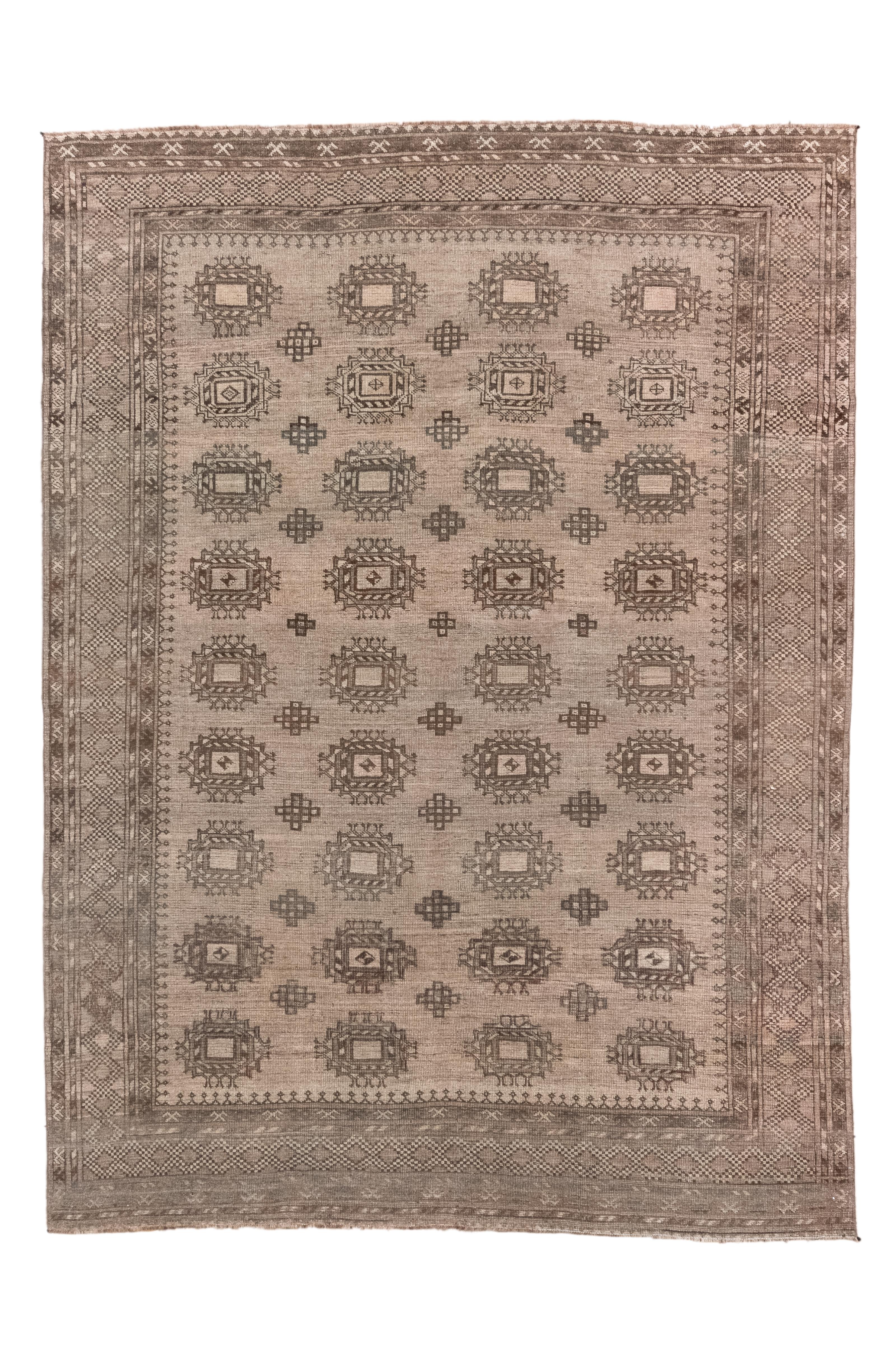 The abrashed mid-brown field displays four independent columns, each of nine Salor-style “Mar” guls, with smaller stepped minor guls in the interstices.  Main border of serrated and chained lozenges. Inner minor of hooked triangles. All wool