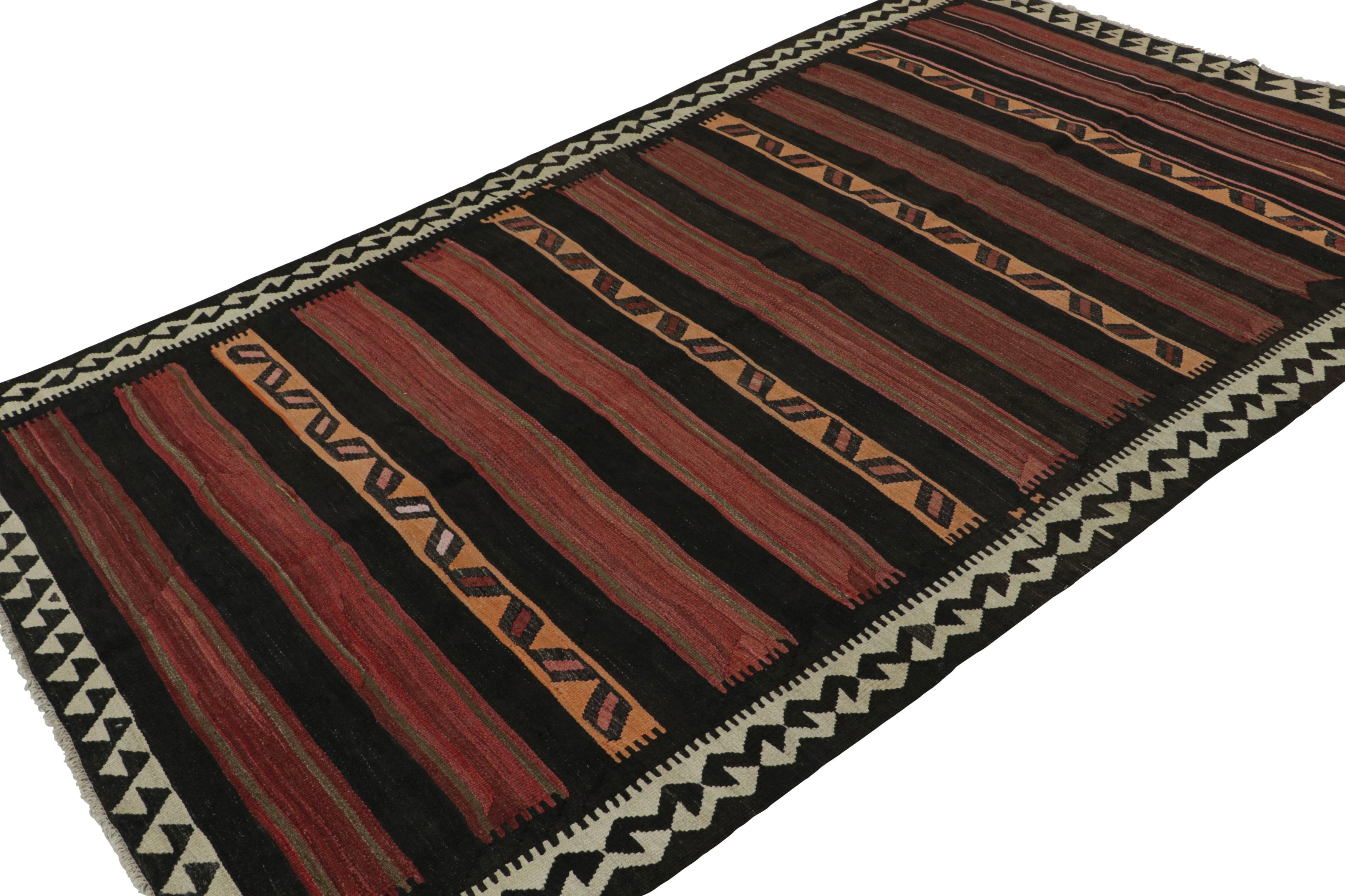 Handwoven in wool, circa 1950-1960, this 6x10 vintage Afghan tribal kilim, in masculine hues of brown, red, orange, black and green border, features fencepost geometric patterns across the entire field. 

On the design: 

As an exciting new curation