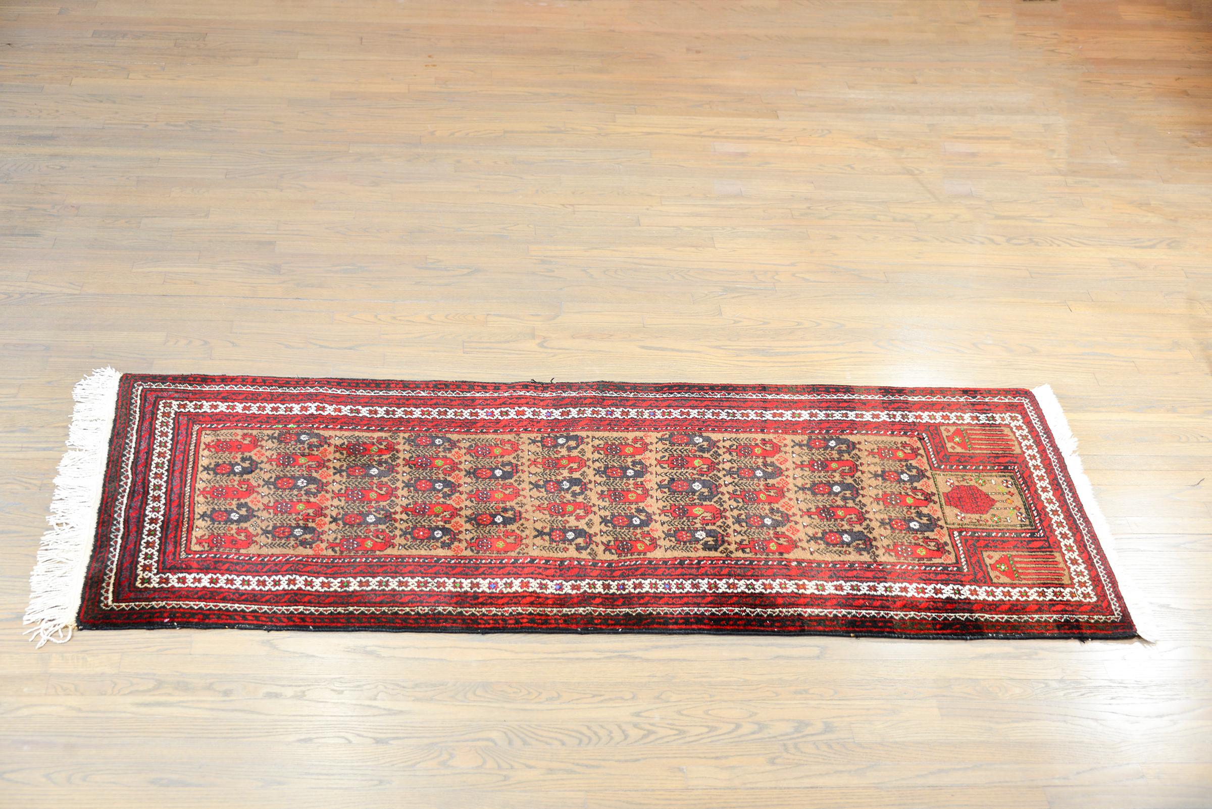 A wonderful vintage Afghani Baluch prayer rug with an all-over paisley pattern woven in crimson and brown wool set against a natural camel hairs background, and surrounded by a complementary petite geometric patterned border.