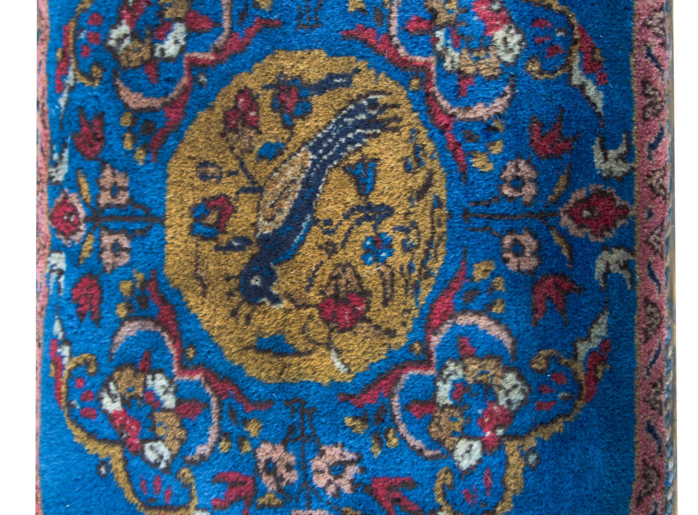 A charming late 20th century Afghani floor pillow hand-woven with a central medallion with a bird and flowers surrounded by scrolling vines and flowers.