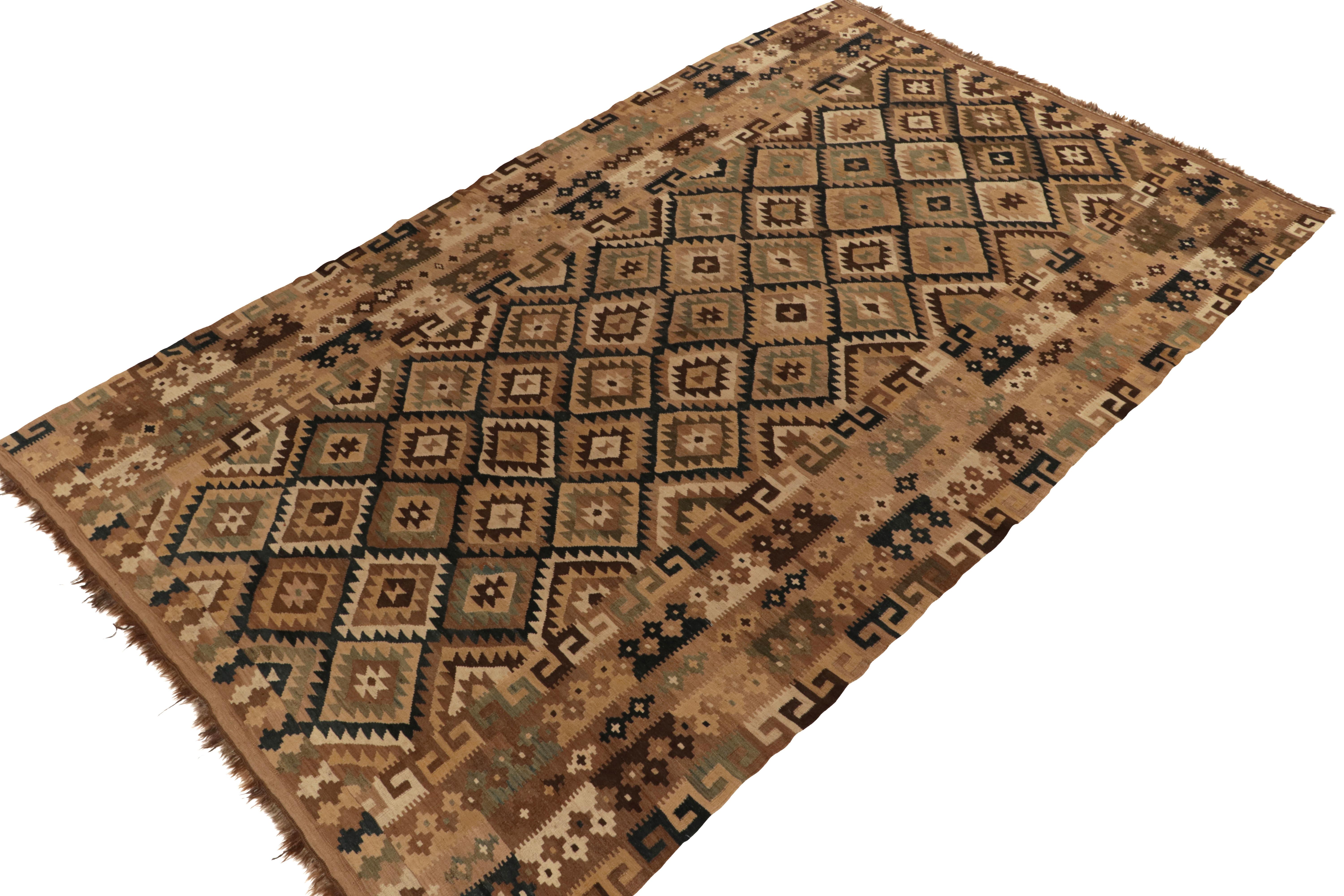 Handwoven in wool, an 8x13 vintage kilim rug from Afghanistan circa 1950-1960. The bold design prefers beige-brown and black with rare teal accents uniquely, and beautifully, complementing the classic tribal aesthetics. The marriage of field motifs