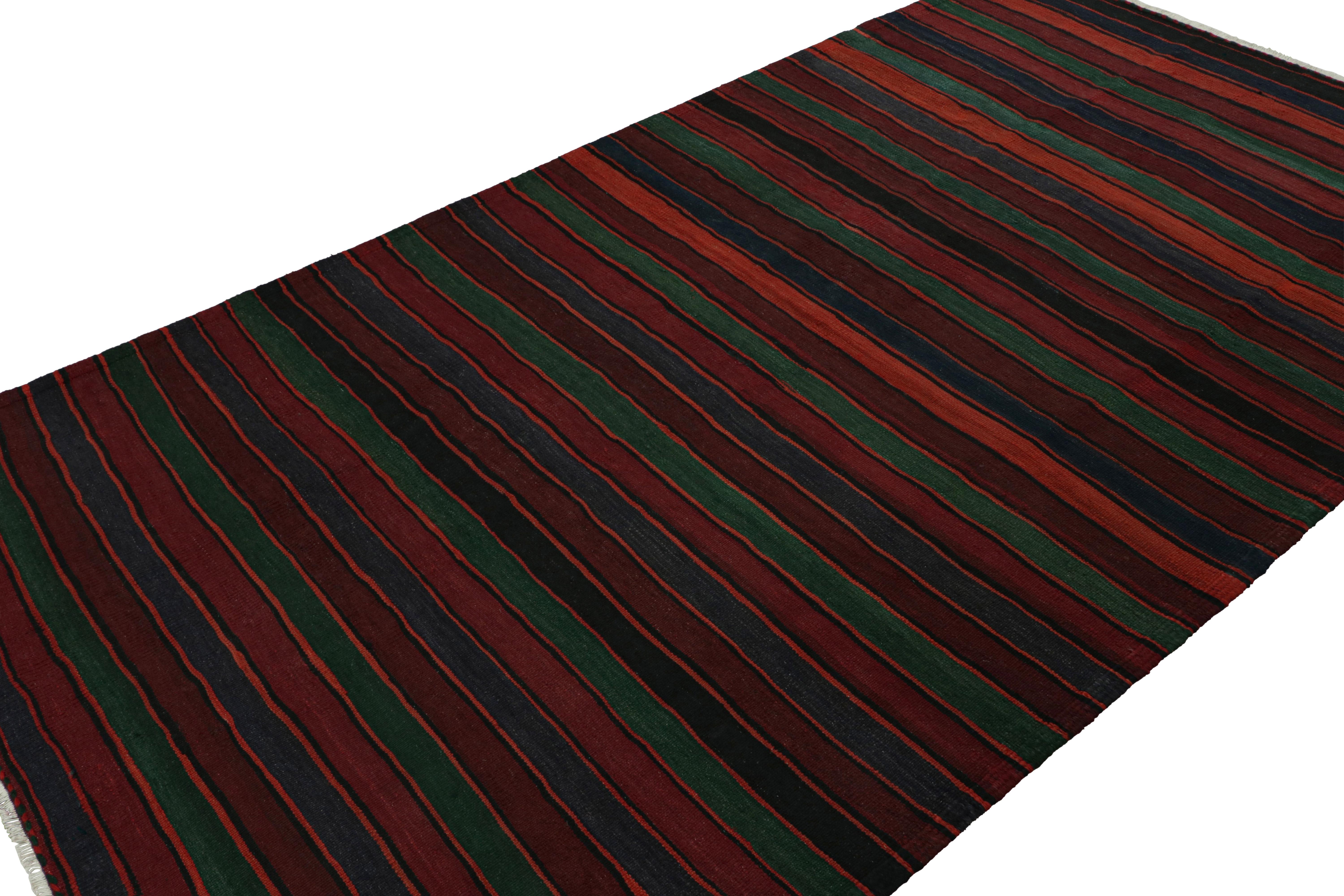 Handwoven in wool, circa 1950-1960, this 5x9 vintage Afghan tribal kilim rug in Burgundy, is an exciting new curation in the Rug & Kilim collection. 

On the Design: 

Keen eyes for detail will admire the striped pattern of the rug, which is