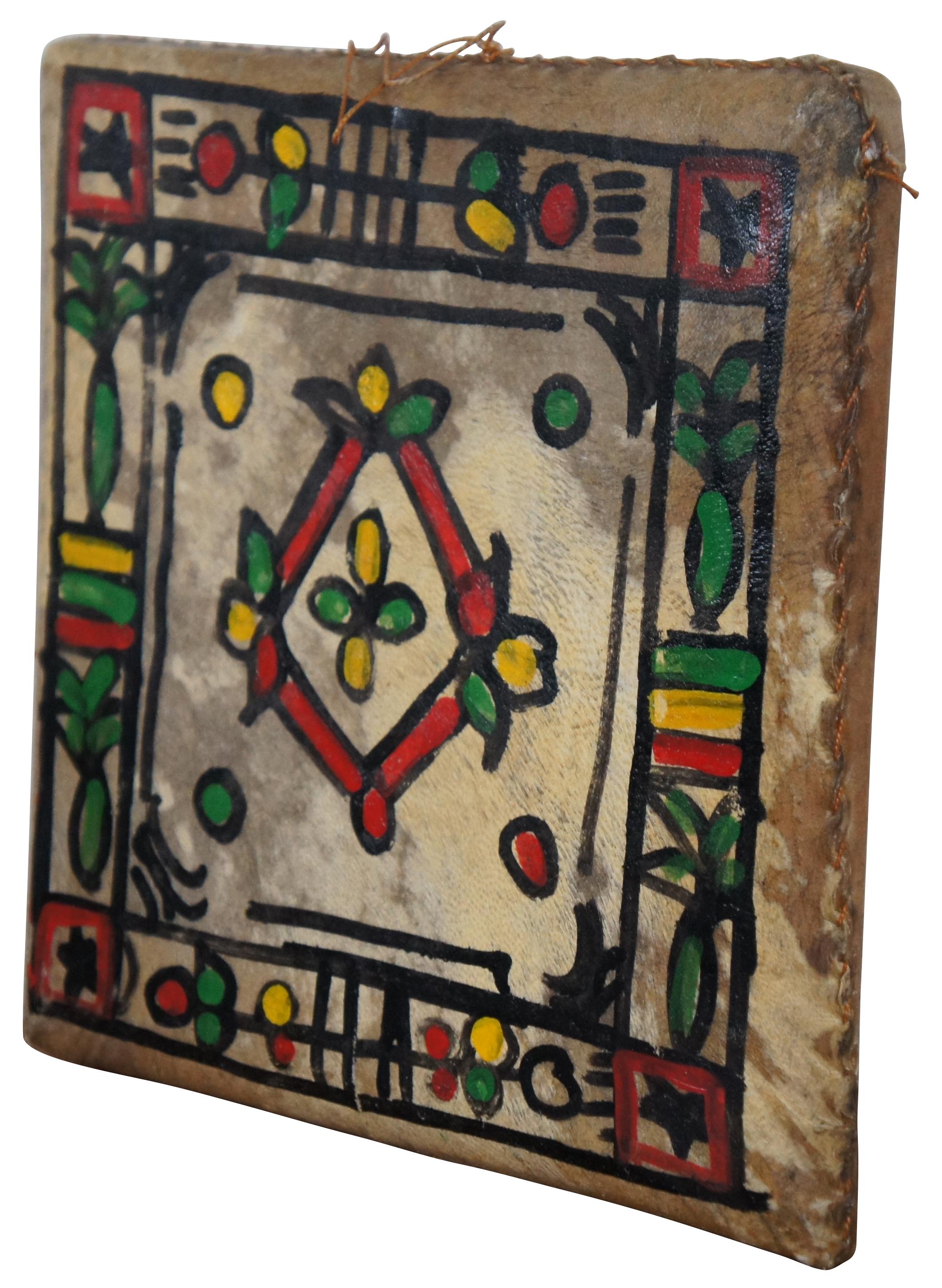 Vintage Berber / Moroccan adufe or square frame drum. This double sided drum is fashioned of a wooden frame covered with stretched leather (usually goat skin), stitched with thick thread and hand painted with a floral motif.

“The adufe is a hand