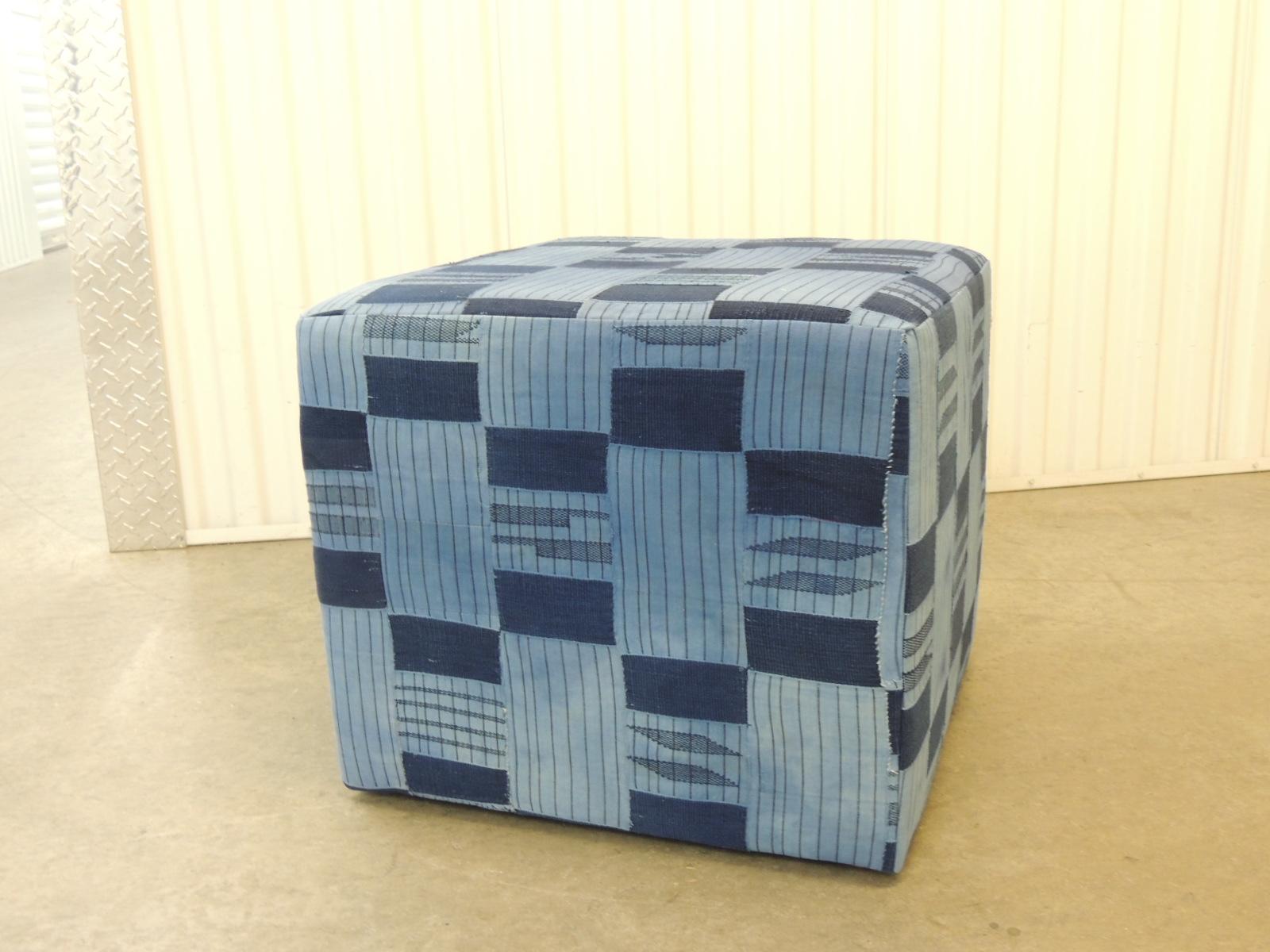 Vintage African blue and indigo woven textile custom square ottoman. Wood frame with padded construction all around and small tack feet.
The Yoruba are masters of the indigo-dyeing process. They also have the most varied methods of applying resists