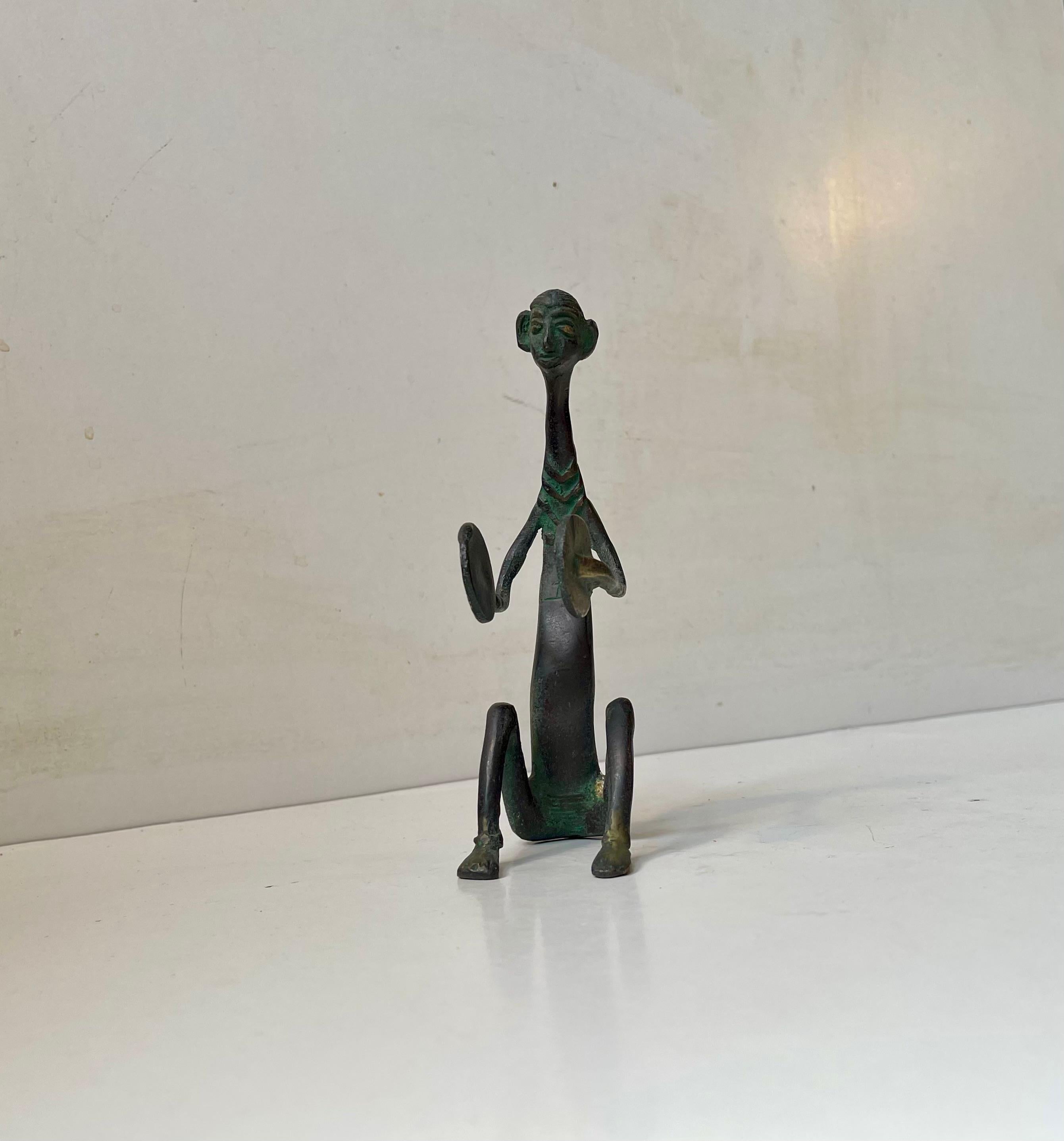Insolita scultura africana vintage in bronzo. Un batterista seduto - suonatore di batteria. È stata portata dall'Africa negli anni '70. Stile ingenuo e primitivo e una forte patina. Questo pezzo non è firmato/marcato. Si integra perfettamente in