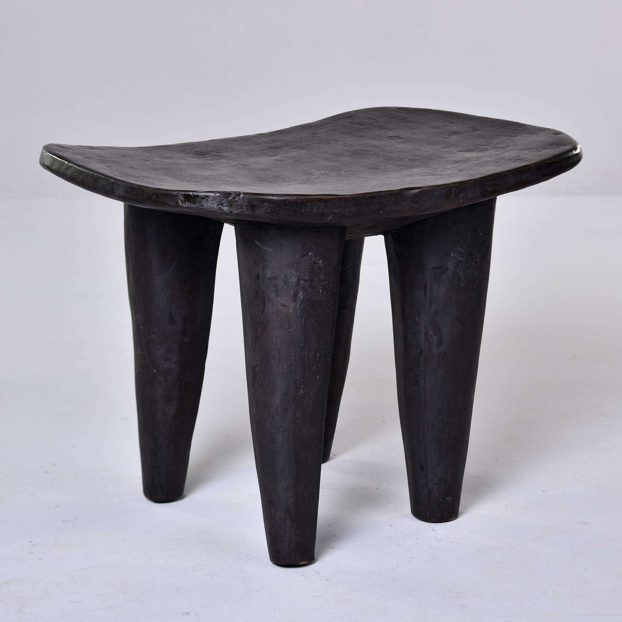 This circa 1980s stool or side table is just under wide. It is hand carved from a single piece of wood with thick, tapered legs by the Senufo people of Cote d’Ivoire. Very distinct and versatile;  this can be used as a stool, ottoman or accent