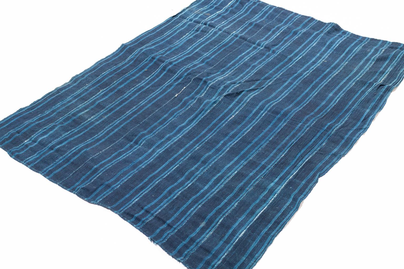 This richly colored natural Indigo dyed and hand-sewn strip weaving is from West Africa.
The cotton is soft and has that beautiful faded feeling that only time can provide. The shades of indigo blue are very rich and have incredible variety.