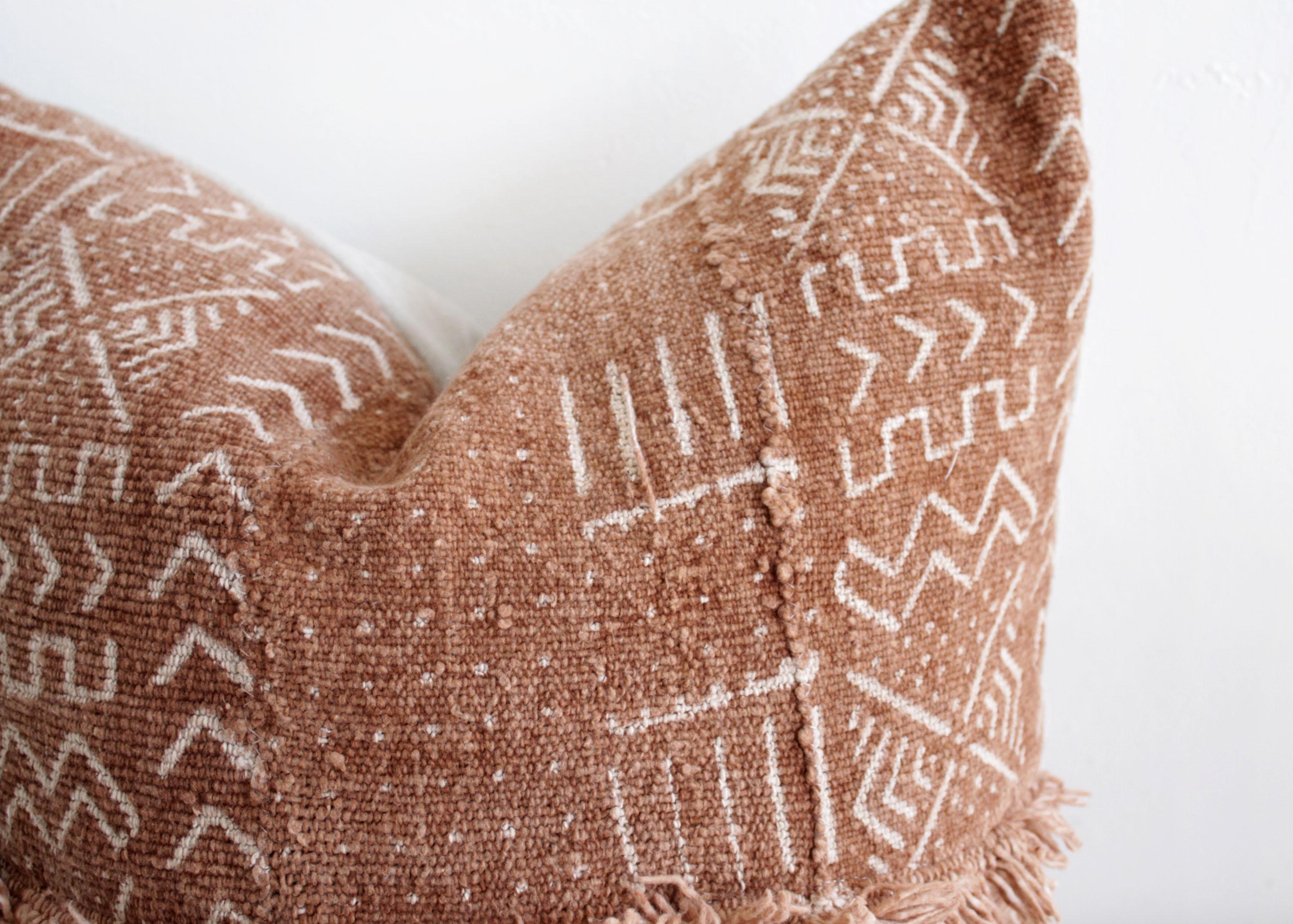 Vintage African Mudcloth pillows with original fringe details A deep burnt orange rust color, with off white arrow pattern, and features original fringe details from the original material. Sewn with a zipper closure, and natural linen backing. The