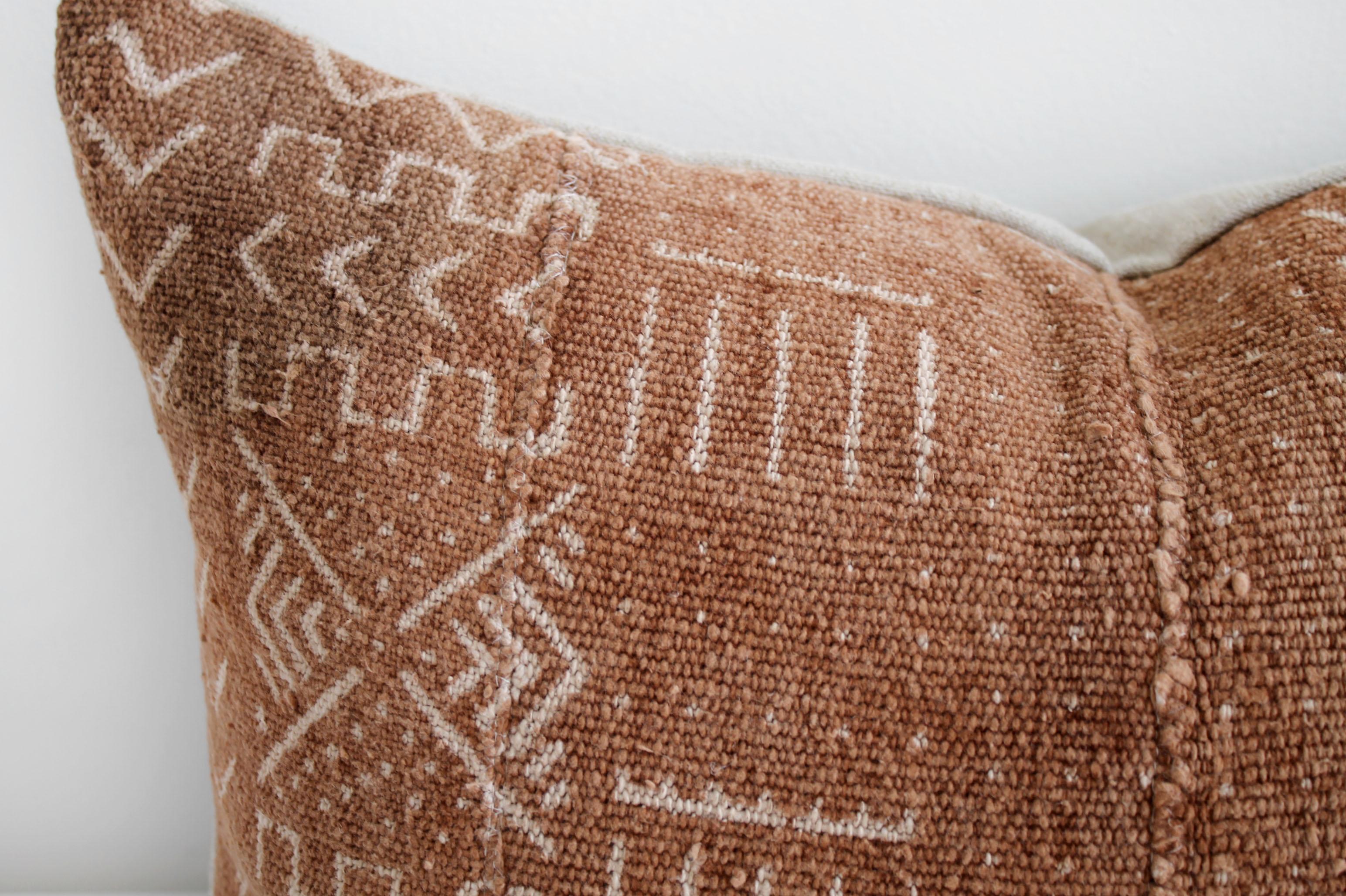 Vintage African mud cloth pillow cover. A deep burnt orange rust color, with off white arrow pattern, and features original fringe details from the original material. Sewn with a zipper closure, and natural linen backing. The inside has an over
