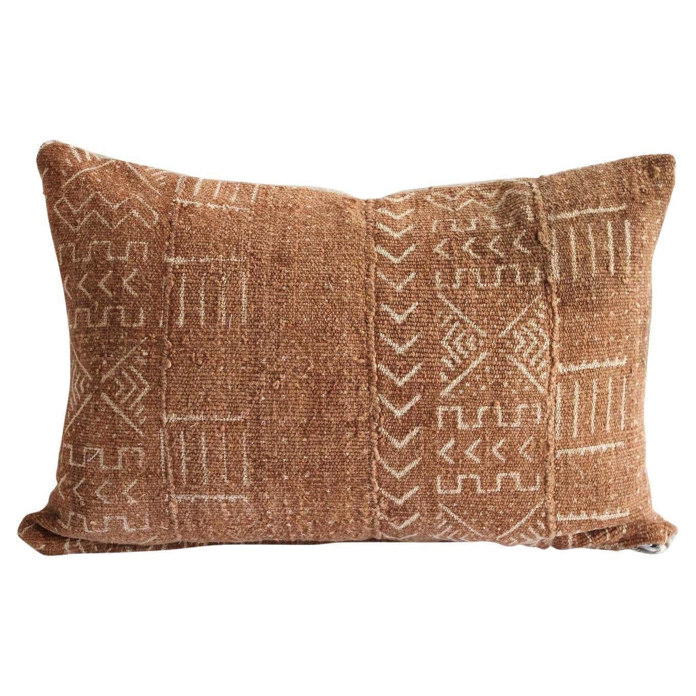 Vintage African Mudcloth pillow. A deep burnt orange rust color, with off-white arrow and mixed patterns. Sewn with a zipper closure, and natural linen backing. The inside has an overlocked edge, can be machine washed on gentle. For color fading dry