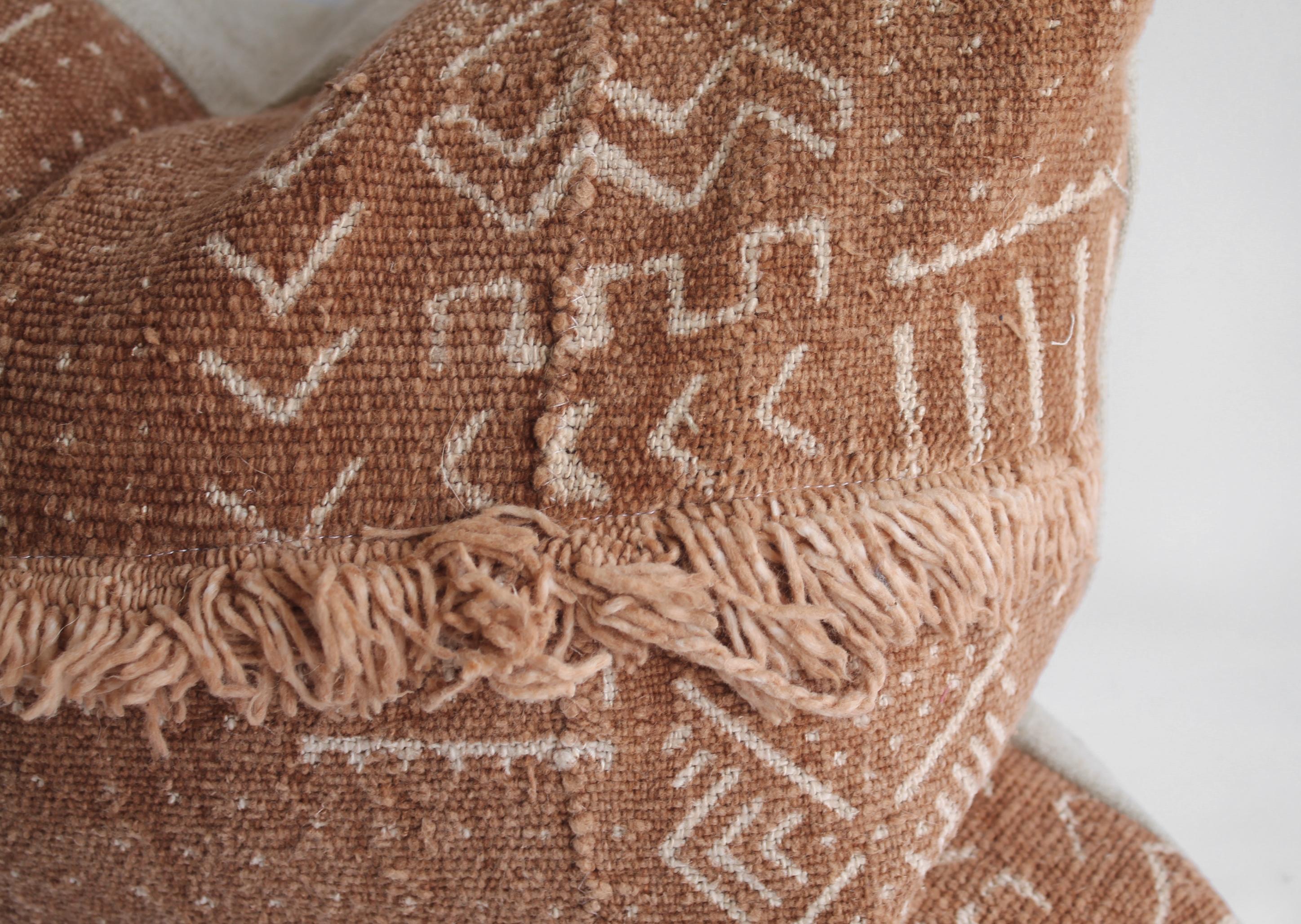 Vintage African Mudcloth pillows with original fringe details a deep burnt orange rust color, with off white arrow pattern, and features original fringe details from the original material. Sewn with a zipper closure, and natural linen backing. The