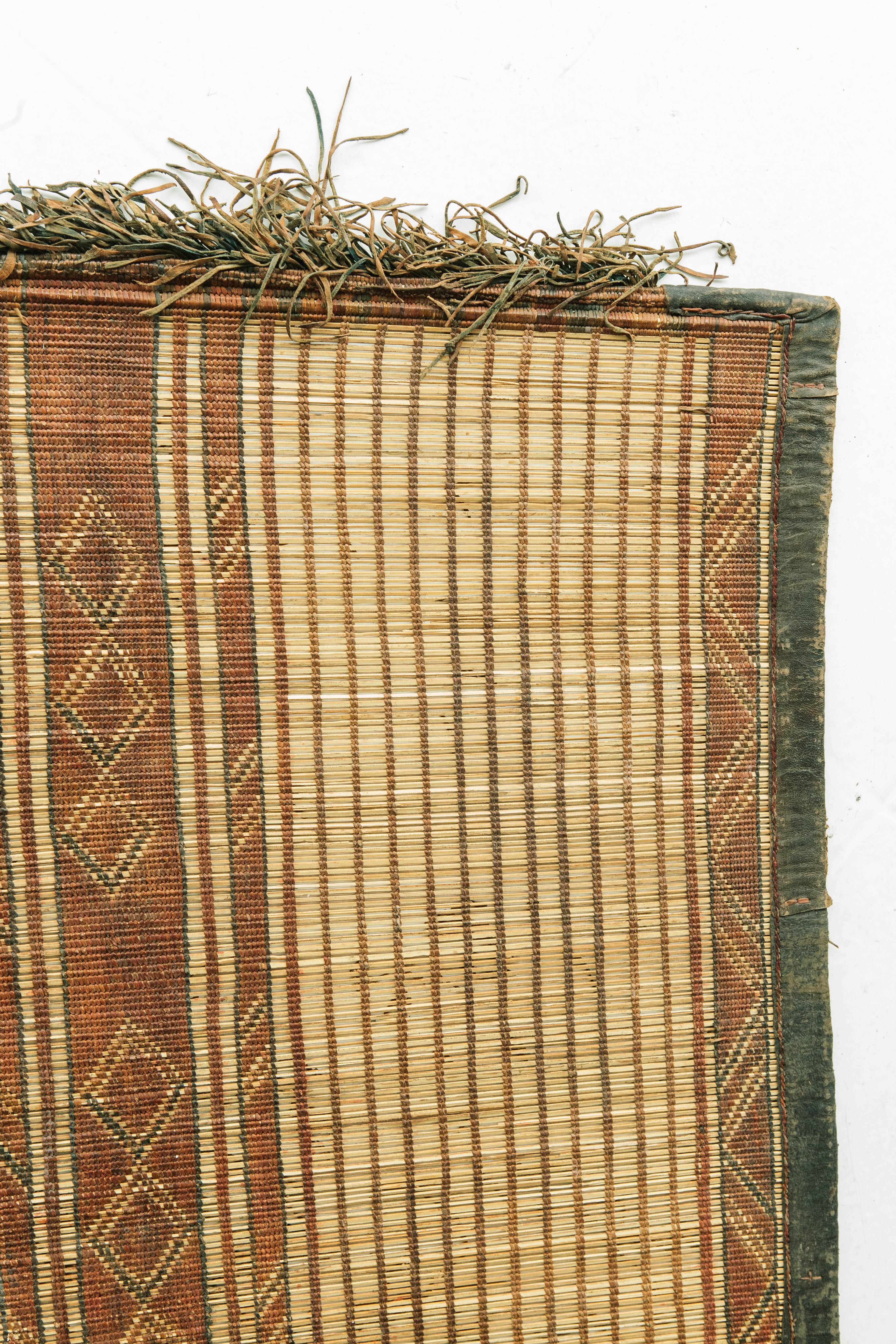 A beautiful and unique vintage Tuareg. This piece is handwoven of reed and leather by one of the oldest nomadic groups of the Saharan trade routes, the Tuaregs. This piece will elevate any design space with its tribal design and eye catching