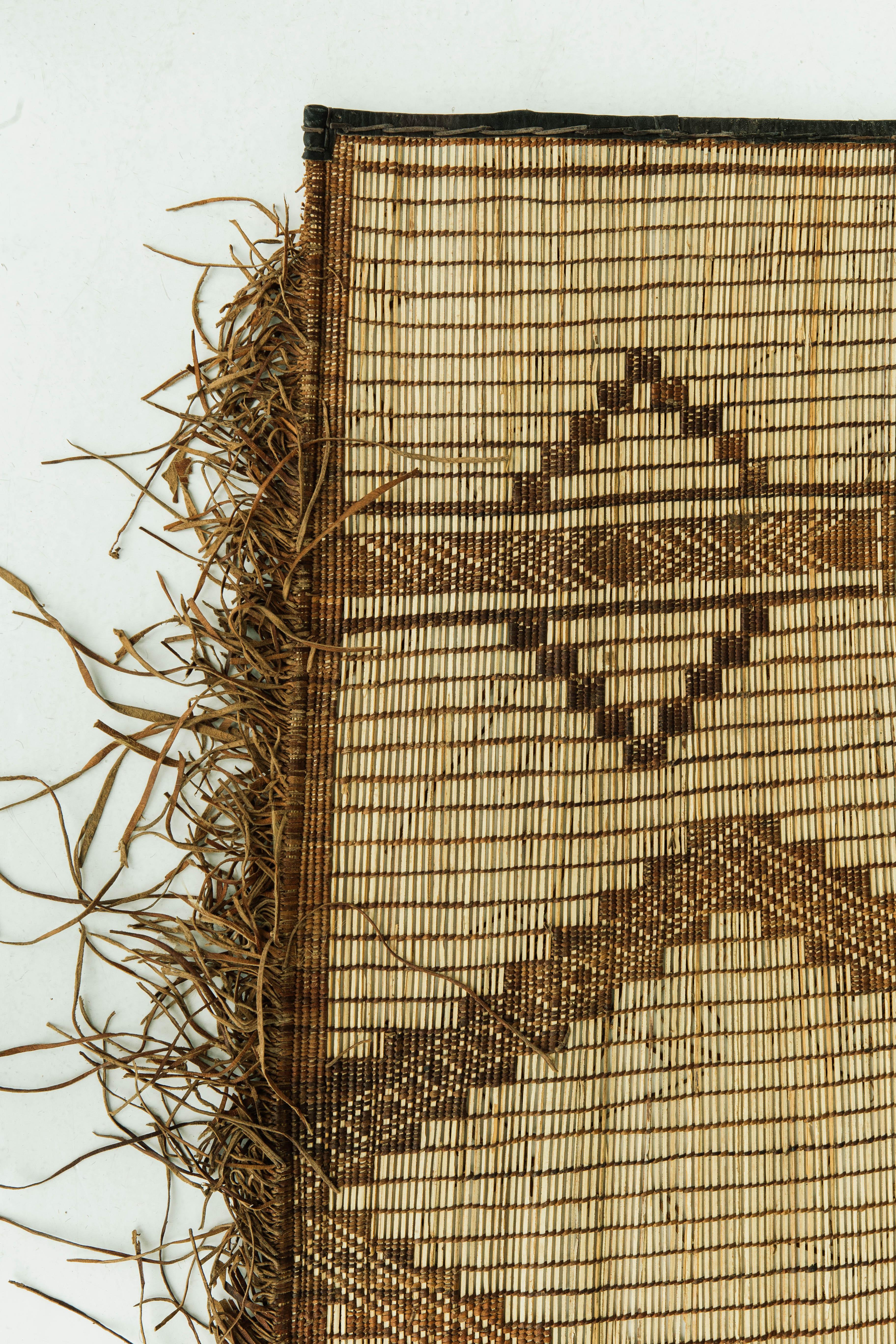 A beautiful and unique vintage Tuareg. This piece is handwoven of reed and leather by one of the oldest nomadic groups of the Saharan trade routes, the Tuaregs. This piece will elevate any design space with its tribal diamond design and eye catching
