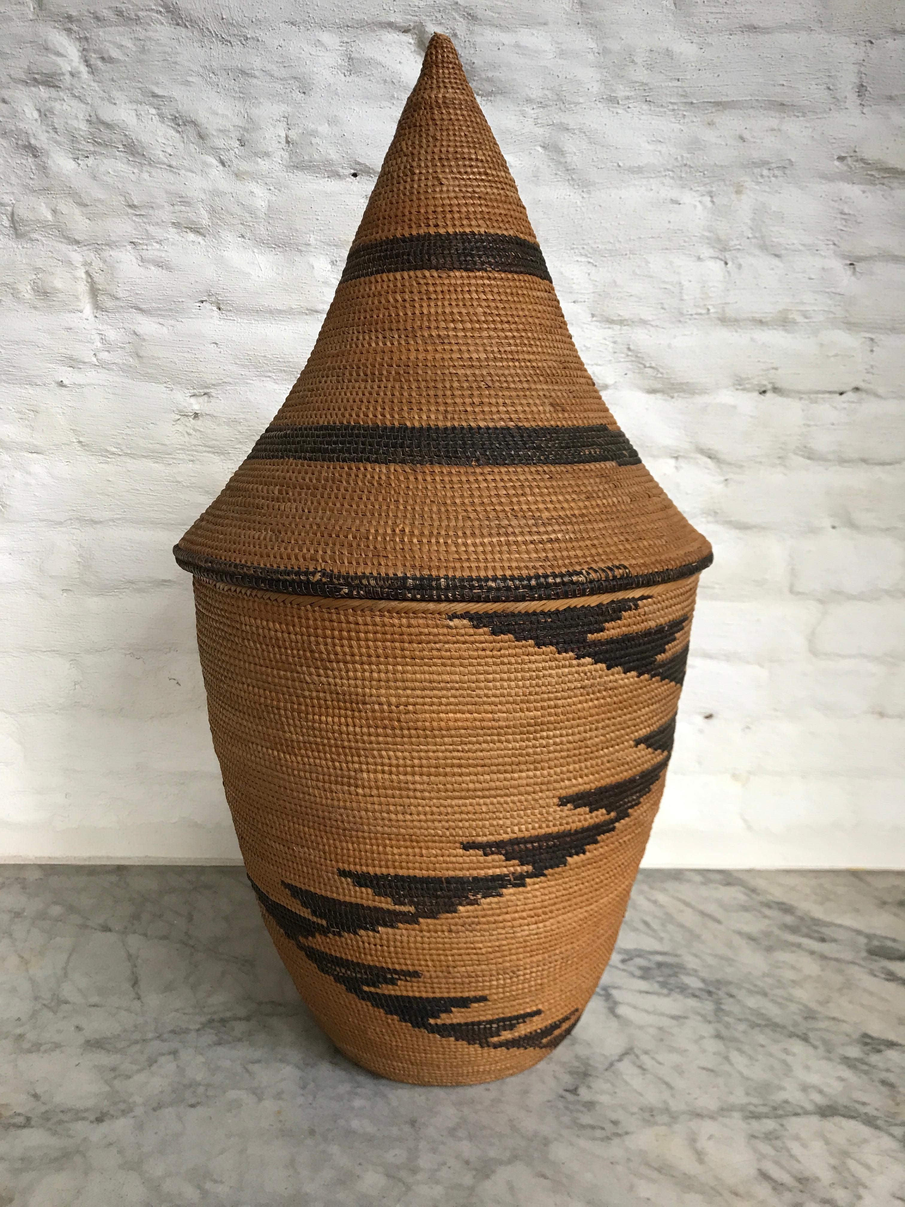 19.75 inches tall mid-20th century handmade lidded Agaseki basket. Tightly woven and in very good condition.
This type of baskets are called Agaseki and were made from vegetable fibers of sisal and papyrus trees (Nigwegwe). The grasses of these