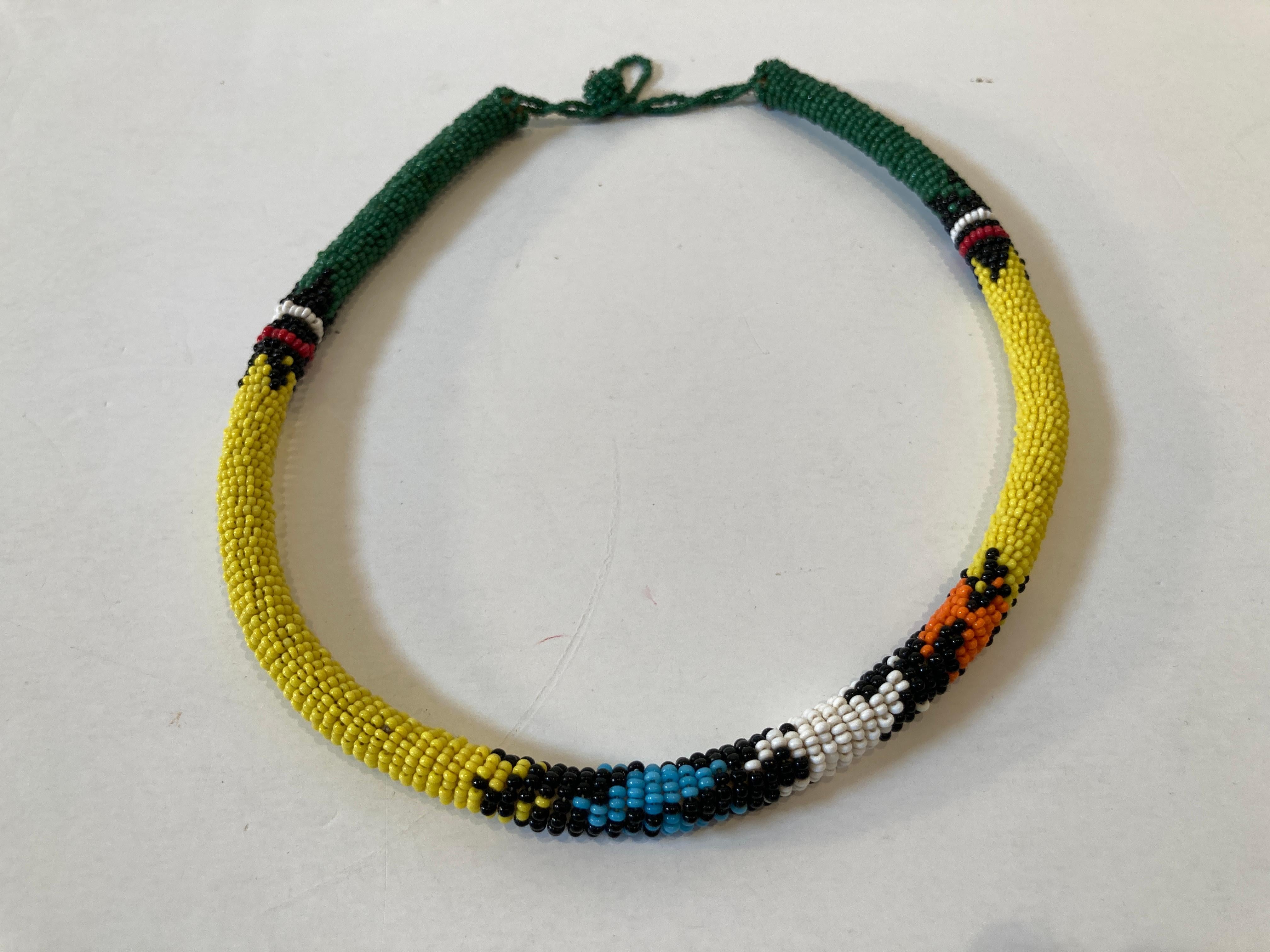 African Urembo Beaded Vintage Halskette Halskette von der Maasai Stamm Kenia
Vintage African Urembo Perlen Halskette Halsband.
Handgefertigt in Kenia vom Stamm der Maasai mit gelben, grünen, orangen und schwarzen Perlen.
Urembo bedeutet