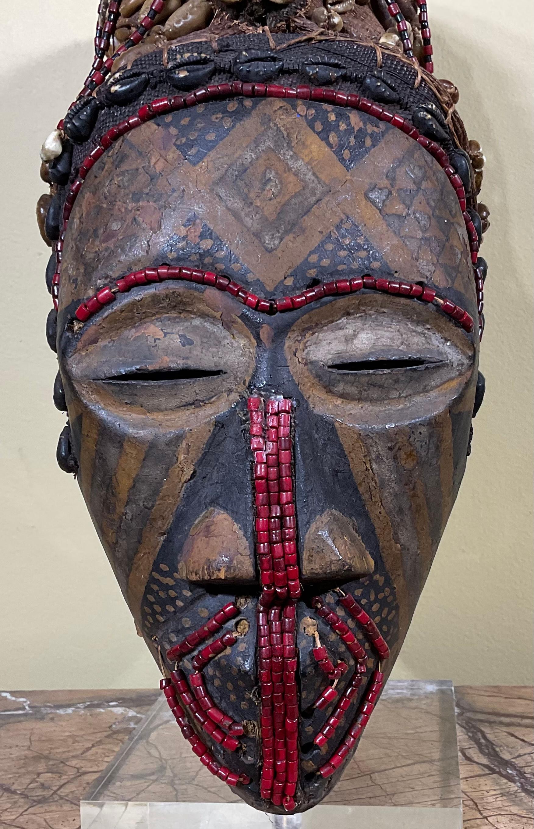 Exceptional looking mask artistically made of combination of hand crafted beads ,shells ,raffia, and hand painted wood. To make such a complete object of art for display.
Custom-made base included.
 