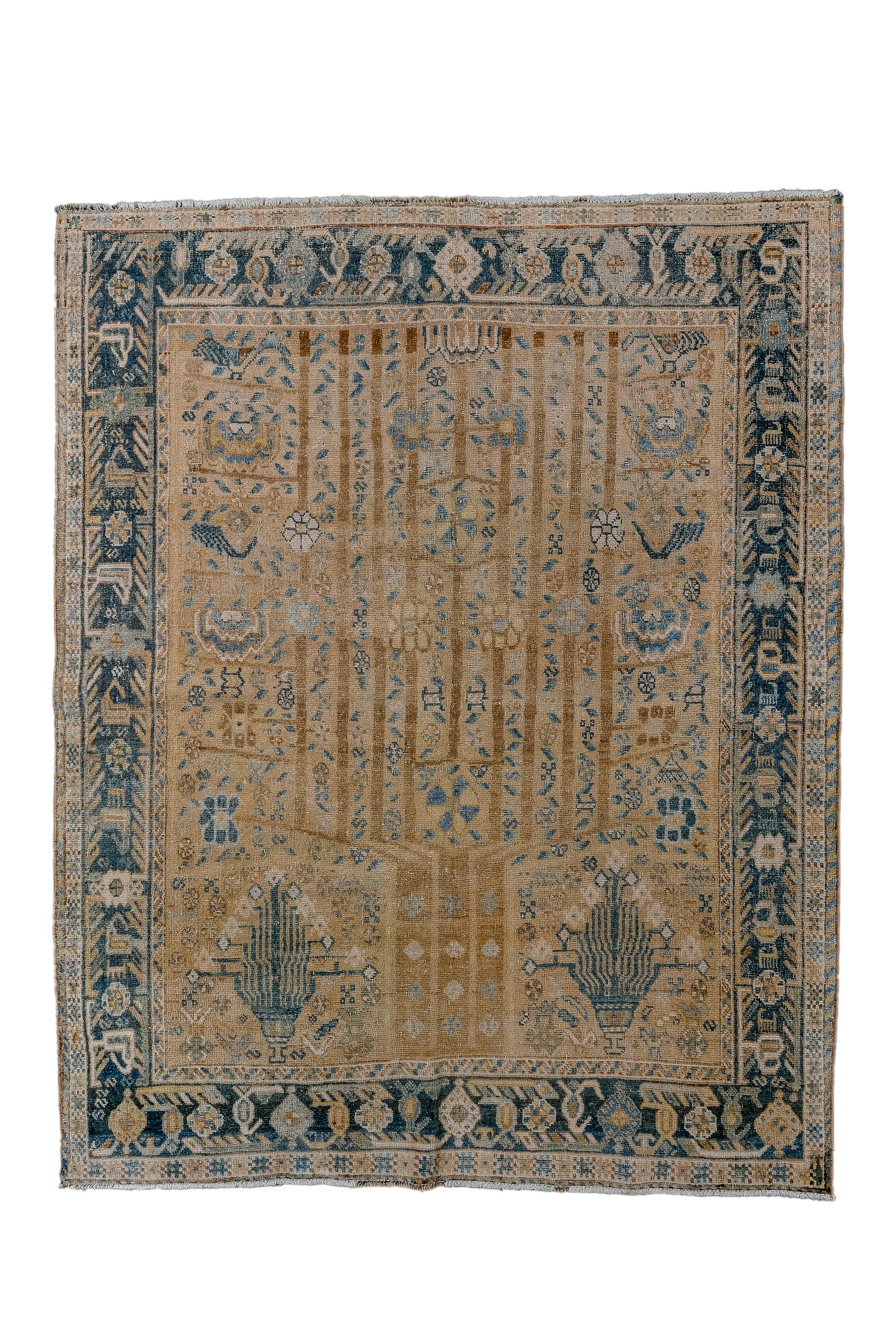 Tabriz with a golden camel field based on two flourishing vases, and with a central three-trunked tree which divides upward nine upraised branches, with flowers, leaves and rosettes on and around the main motif.  Strip style slate main border with