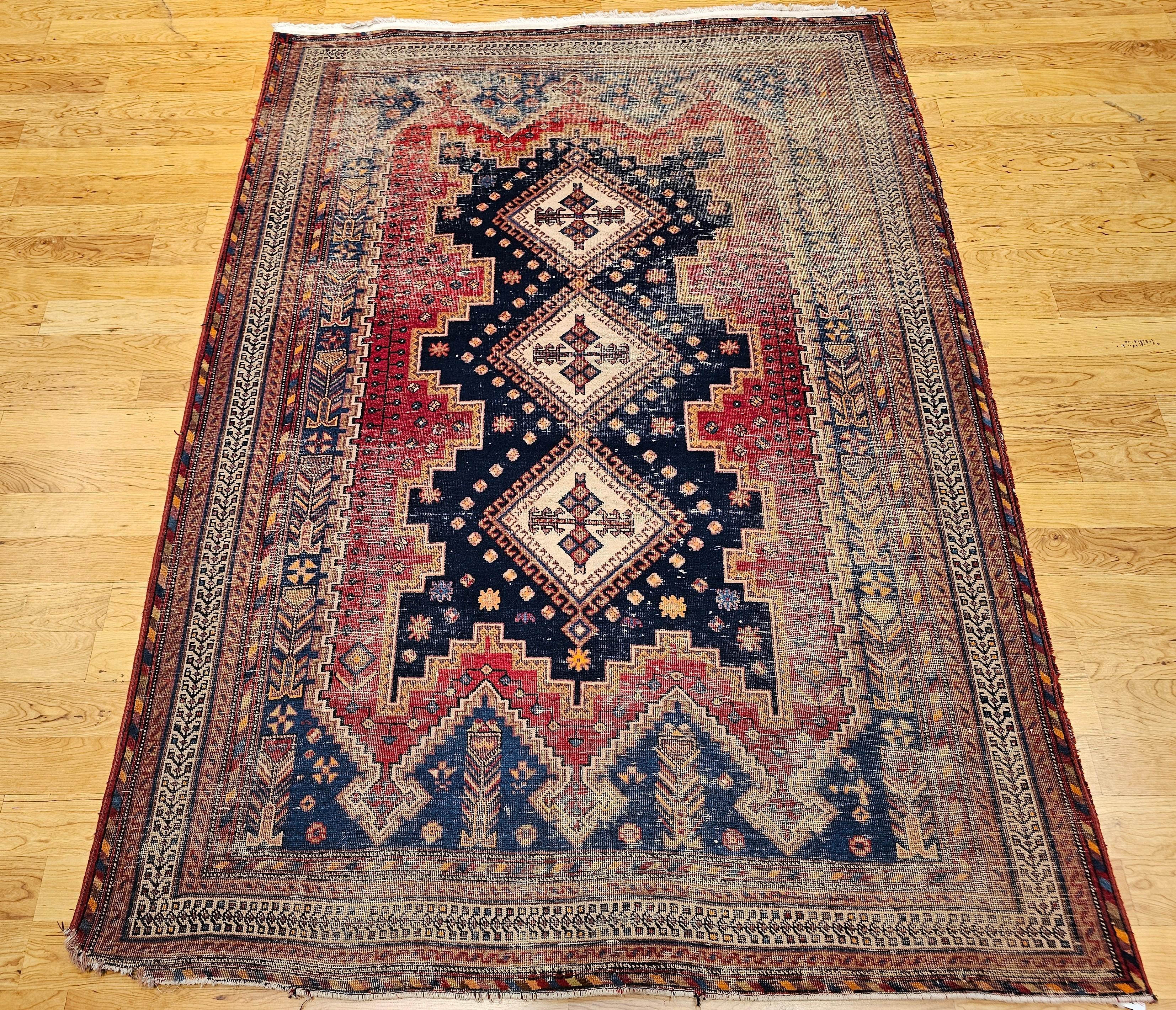 Vintage Persian Afshar Tribal Flächenteppich in einem geometrischen Muster in Marine, Rot, Blau, Braun und Elfenbein Farben aus den frühen 1900er Jahren.  Der Teppich hat einen marineblauen Hintergrund mit roten und französisch-blauen Zwickeln.  Die