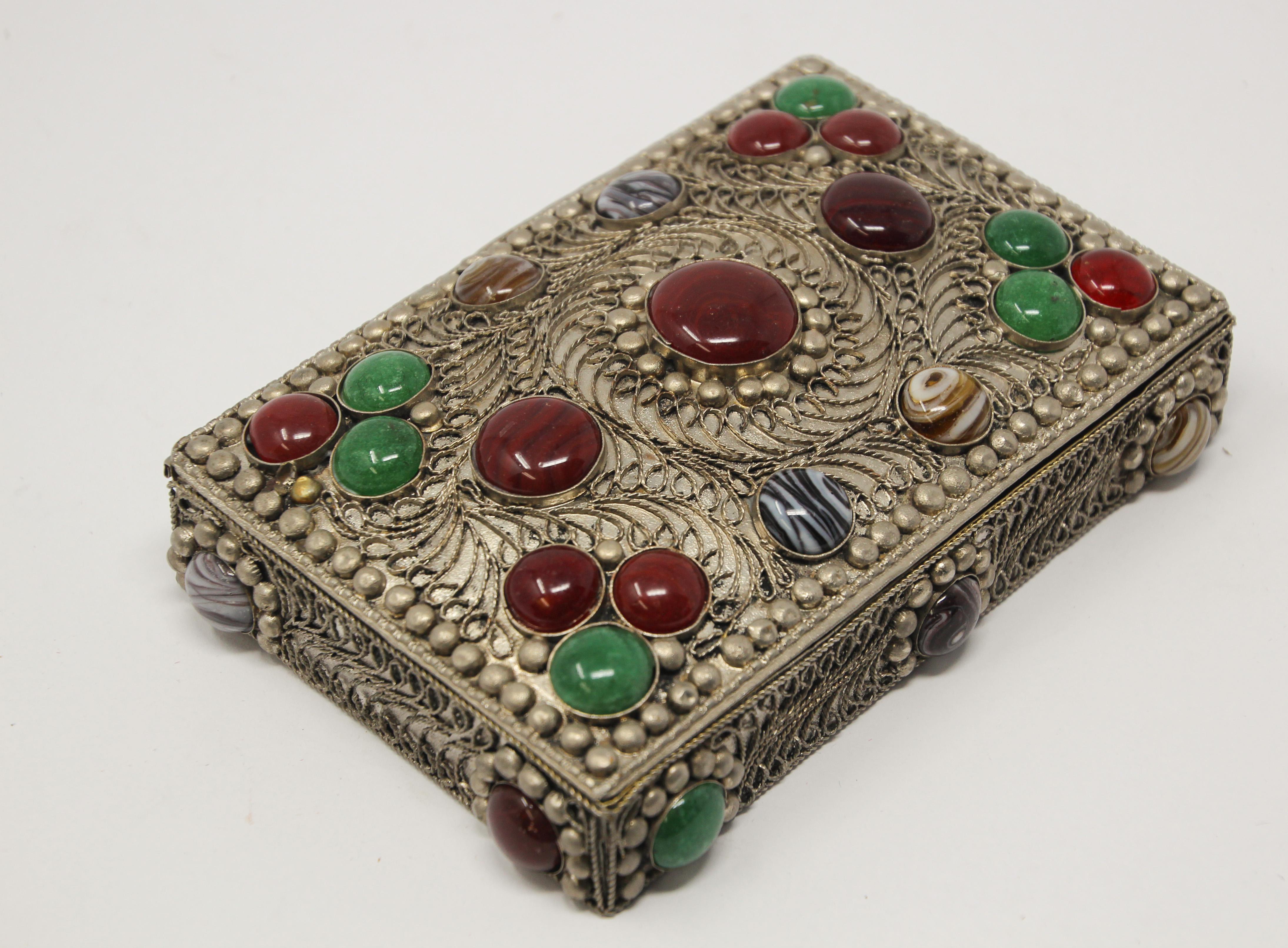 Vintage Moroccan jewelry box inlaid with semi-precious agate stones and covered with silvered metal filigree.
Moorish Middle East jewelry dressing box, very impressive.
Brass silvered vintage trinket box.
   