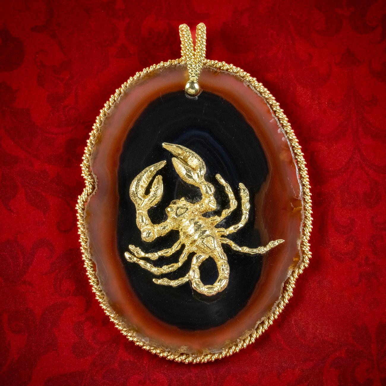 A remarkable vintage Scorpio Zodiac pendant built around an enormous, flat cut agate with a striking 18ct gold scorpion on top. It has been intricately detailed and contrasts beautifully against the agates black core with beautiful, chocolate brown