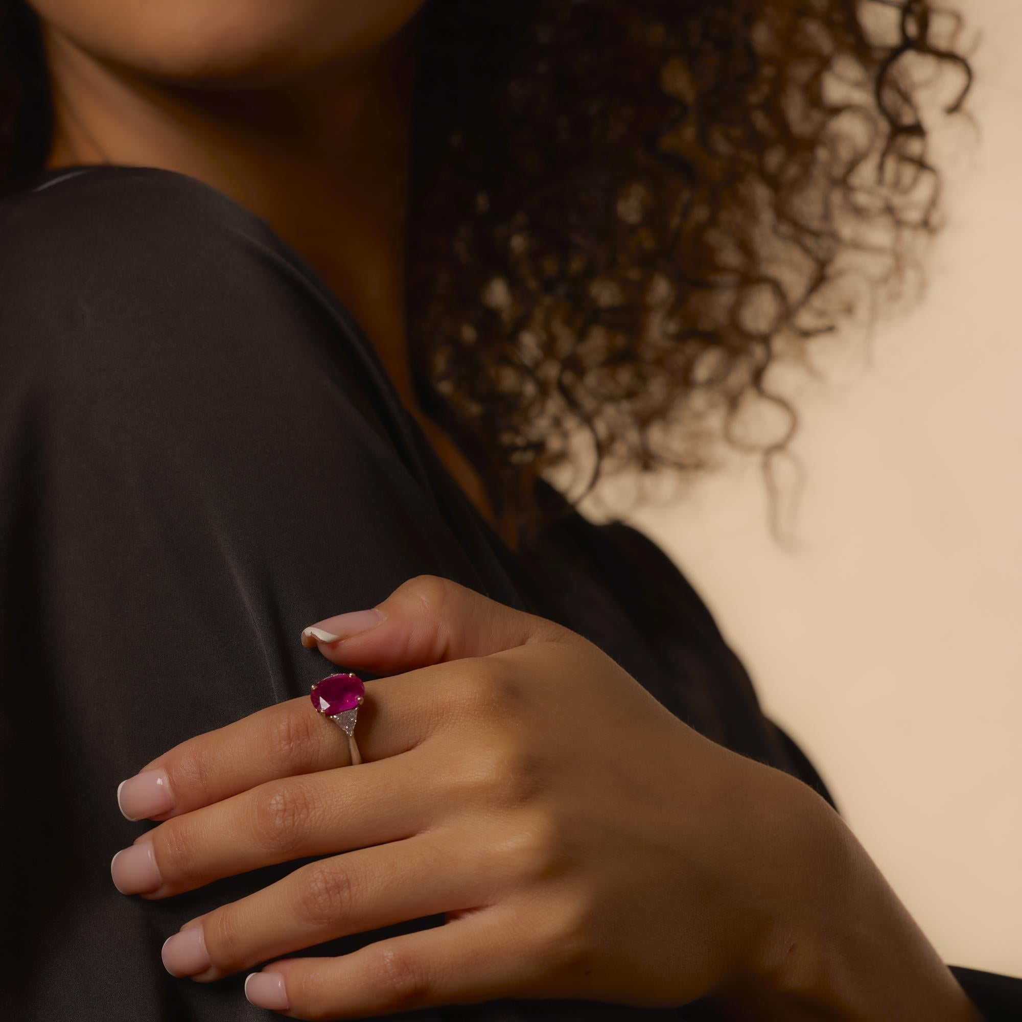 This vintage platinum and 18k gold ring centers a vivid 4.68 carat no-heat Burmese ruby, accented by trilliant diamonds for timeless elegance and bold sophistication.