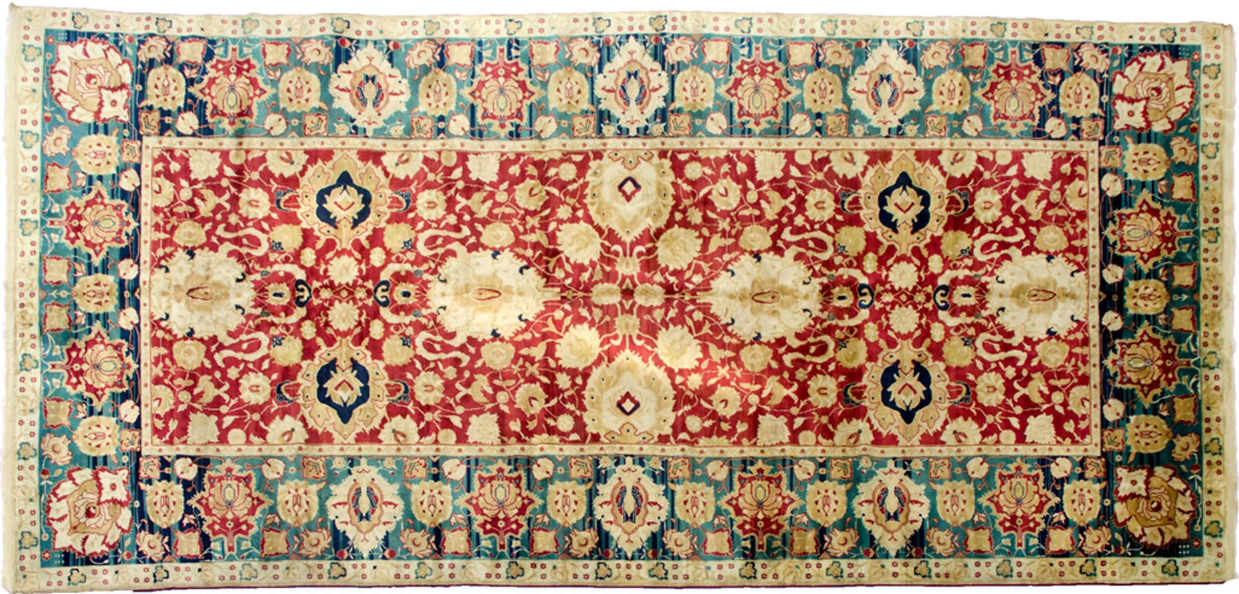 Impressive vintage Agra carpet from India. This is a fine, very high quality production piece with high quality dyes and wool. Soft red ground is decorated with large and small palmettes with small cloud band motif. The impressive green blue border