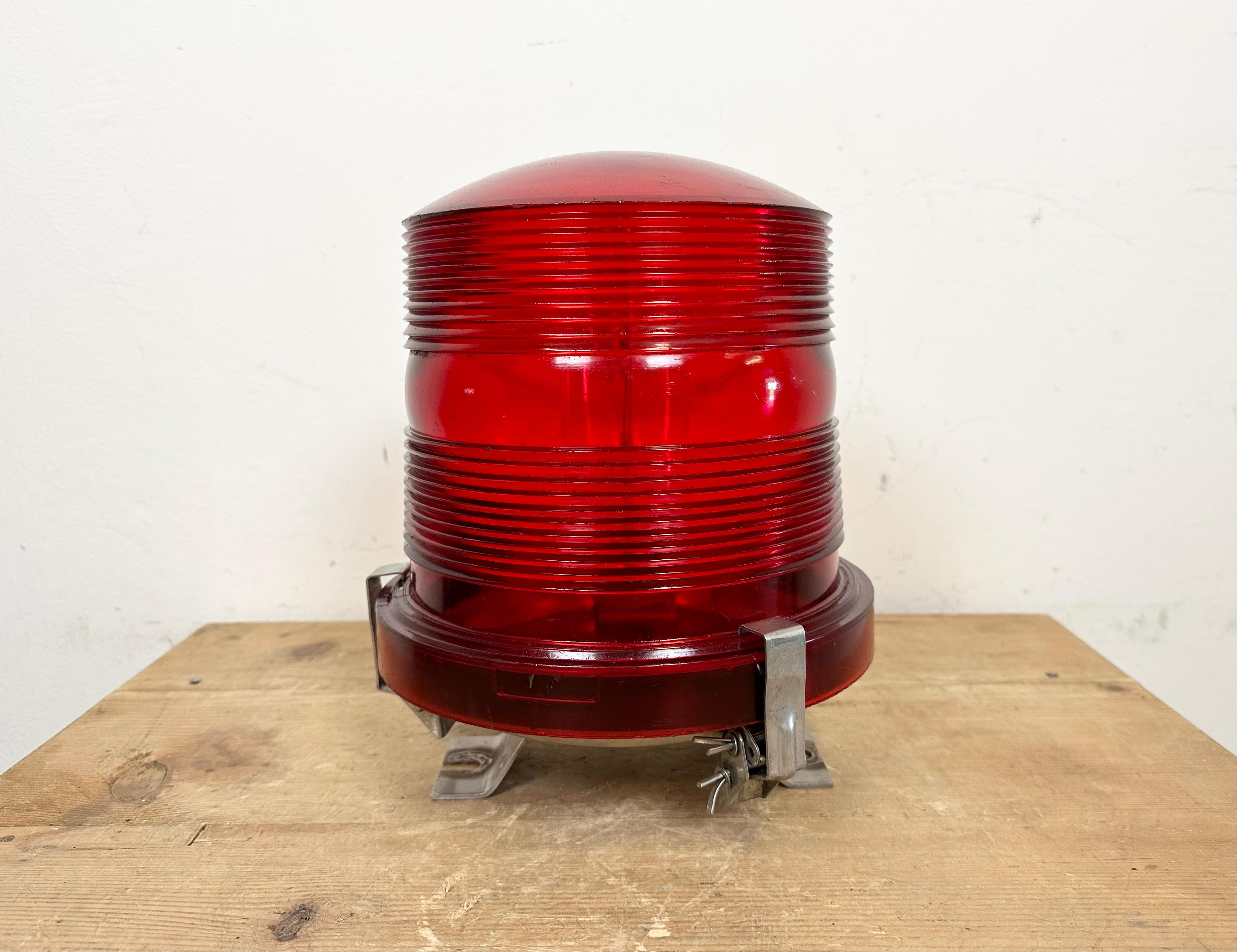Lampadaire industriel vintage de piste d'aéroport fabriqué par Polam Wilkasy en Pologne dans les années 1960. Il est doté d'une fixation au sol en fer et d'un couvercle en plexiglas rouge.
Le diamètre de la lampe est de 23 cm. Le poids est de 1,7