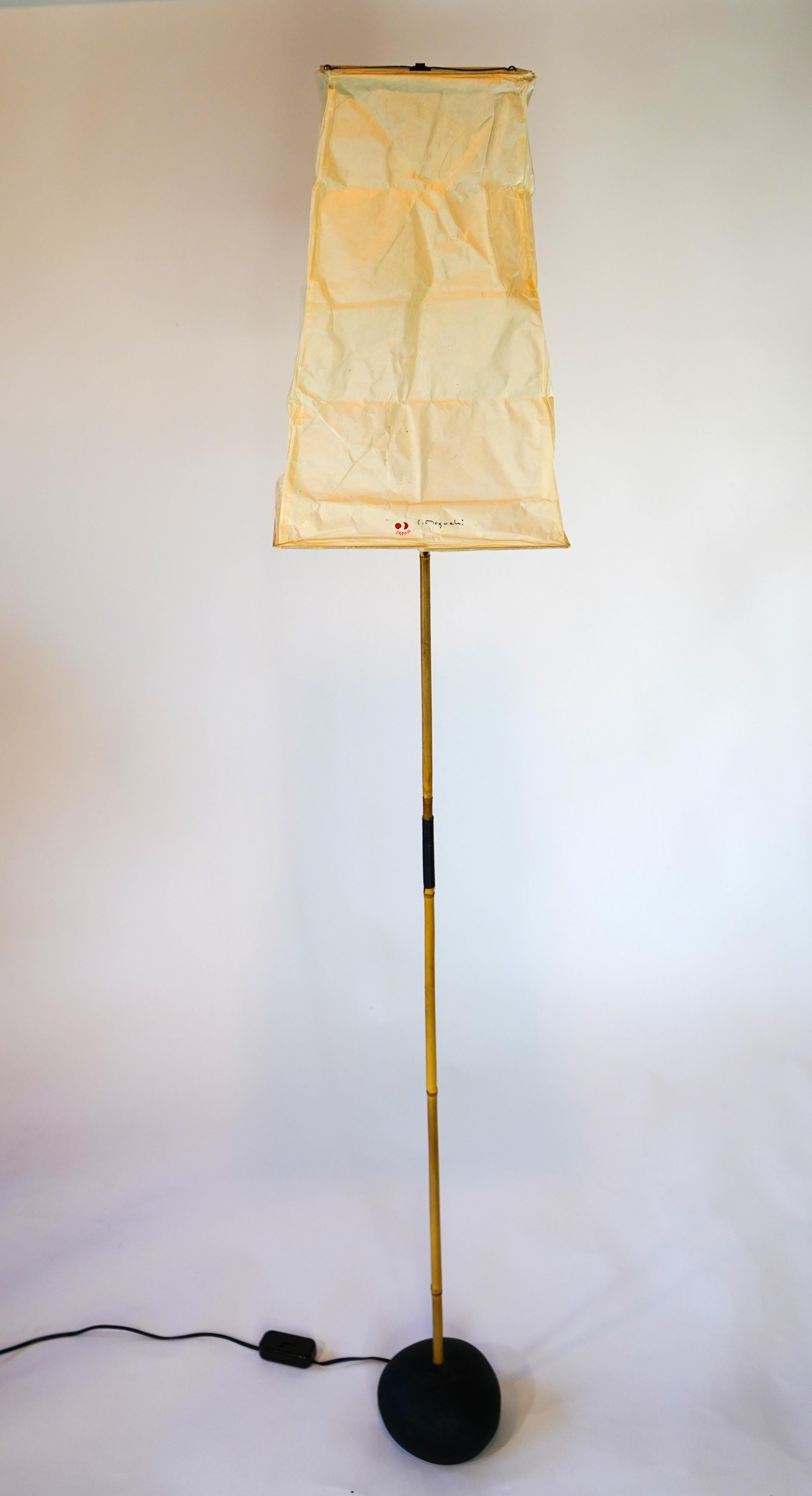 Vintage Akari floor lamp by Isamu Noguchi with V1 shade. Bamboo pole attached to iron base and rice paper shade signed. Shade is in great condition with minimal wear.