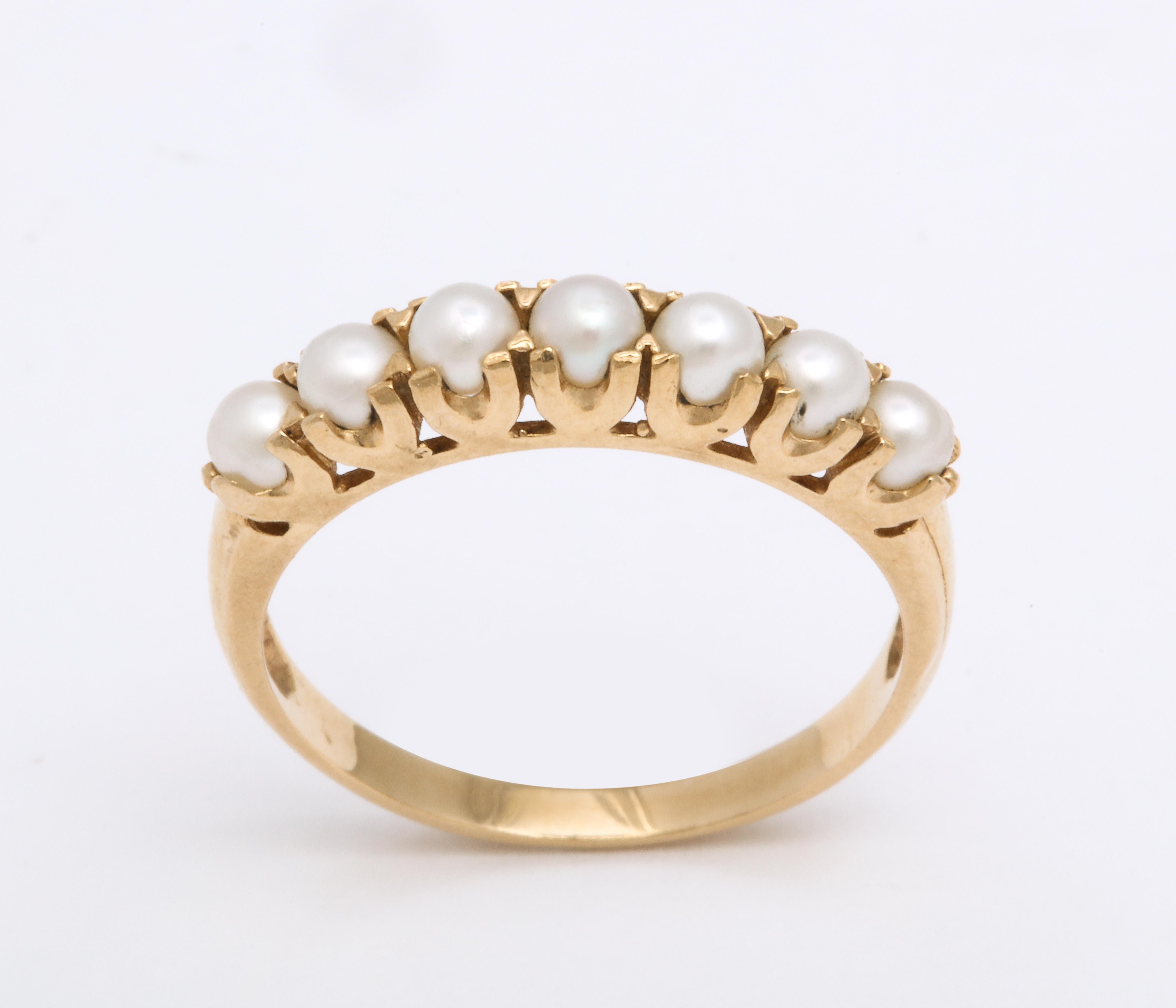 Seven lustrous pearls are perfectly matched to wrap your finger in this elegant half hoop band.
The gold is 10 Kt in a color that easily can be joined with other bands or or pearl gemstone rings. Notice the sturdy horseshoe prongs certain to secure