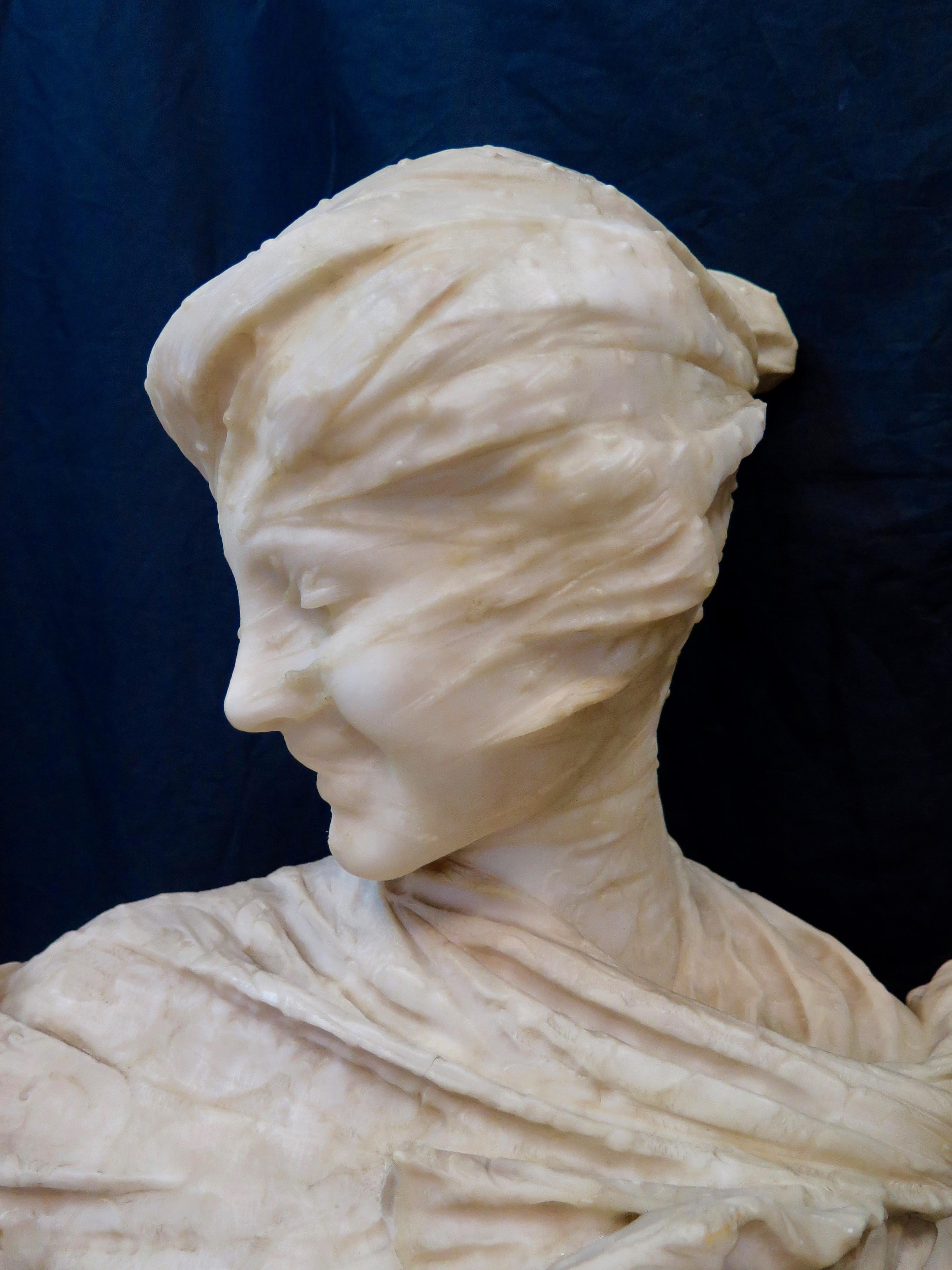 This vintage hand carved late 19th century Italian alabaster sculpture is signed E. Fiaschi. This exquisitely rendered depiction of a fashionable lady is presented wearing a tight see through veil wrapped around her face. Fiaschi's expertise & keen