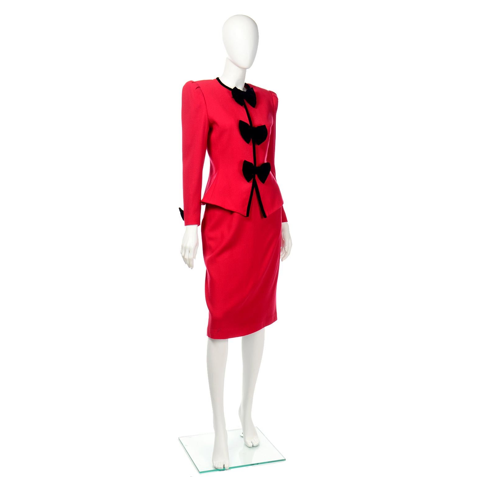 This is a fun vintage 2 piece skirt and jacket suit from Albert Nipon in red wool with black velvet trim and bows. We love the dramatic bows and the fitted waist on the jacket.  The fully lined suit jacket has the bows on the front that conceal the