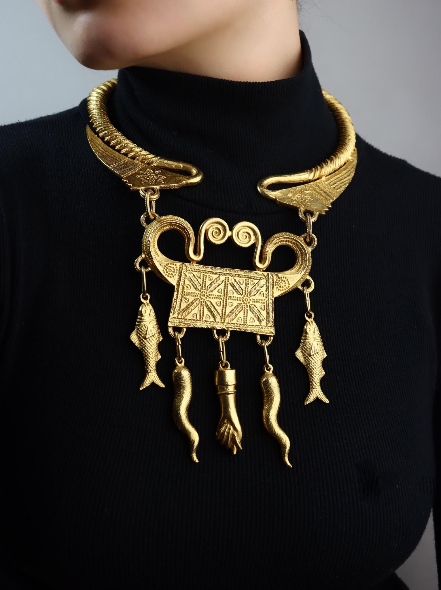 Vintage Alexis Kirk Gold Tone Festoon Bib Choker

Marked:
Alexis Kirk

Approximate Dimensions:
57 cm (Length) 
1.2 cm (Width)
11 cm (Pendant Length)
9 cm (Pendant Width)
191.7 grams in weight.