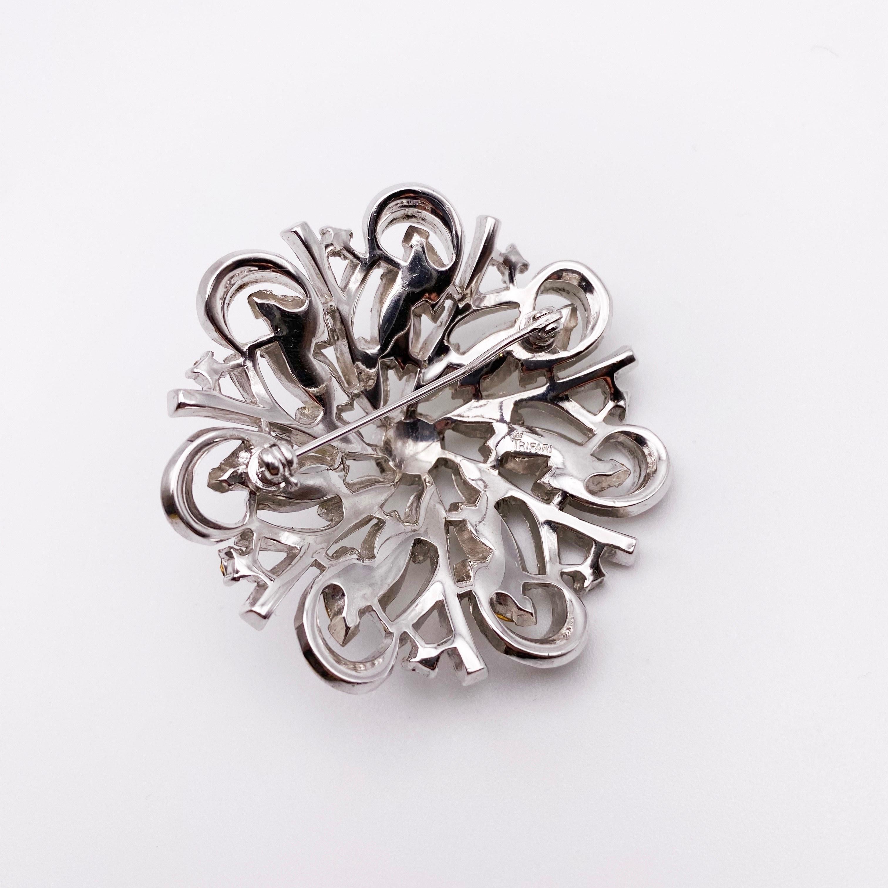 Circa, 1950s. A beautiful Alfred Phillipe Trifari crystal flower brooch. Featuring navette, baguette and pave' clear crystal rhinestones. Set in rhodium plating.  

Trifari's flowers are a collecting field in their own right. Generally, of more