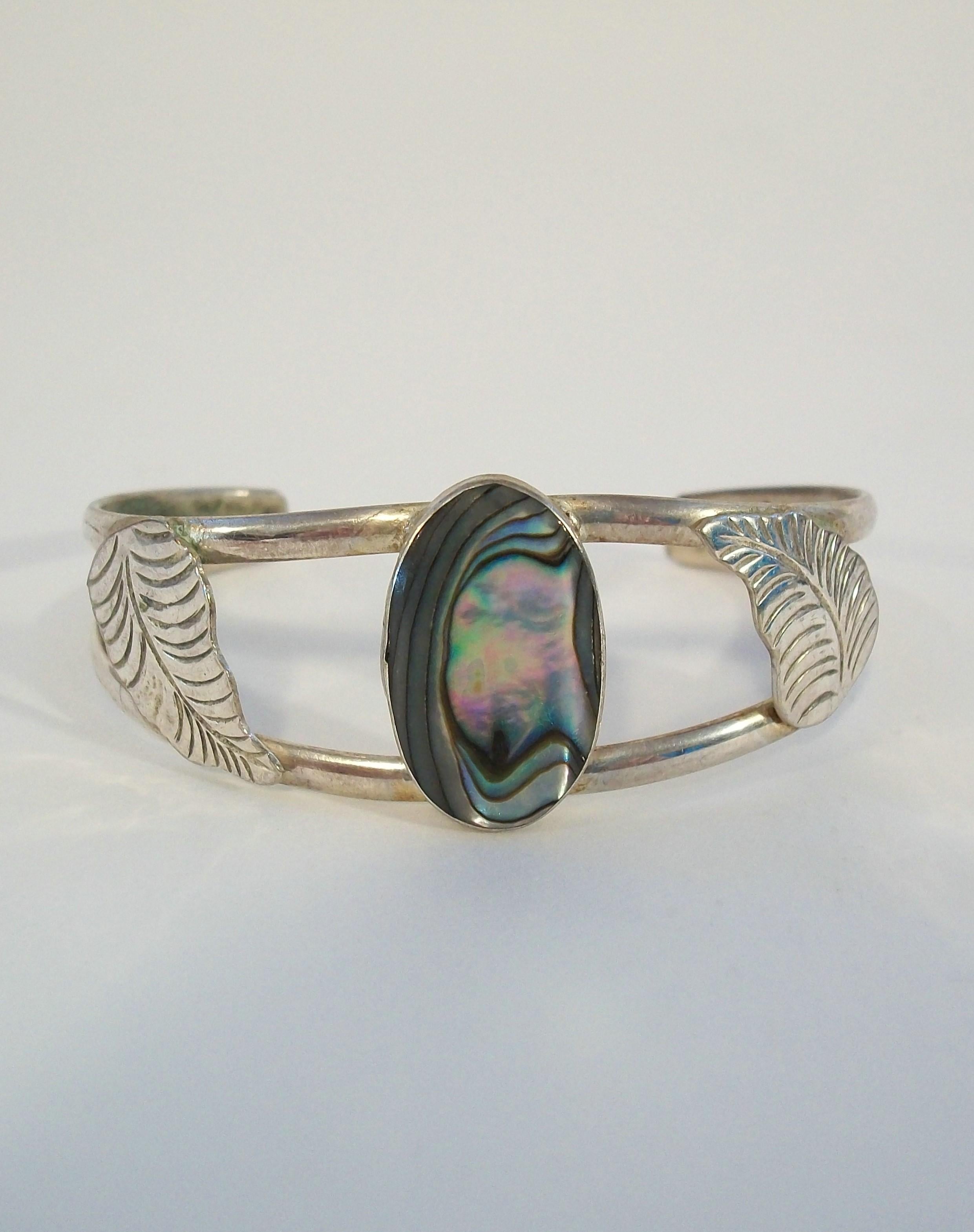 Vintage Alpaca silver (nickel silver) cuff bracelet - featuring a bezel set abalone shell in the center with articulated leaves to either side - signed - Mexico - mid 20th century.

Excellent vintage condition - no loss - no damage - no repairs -