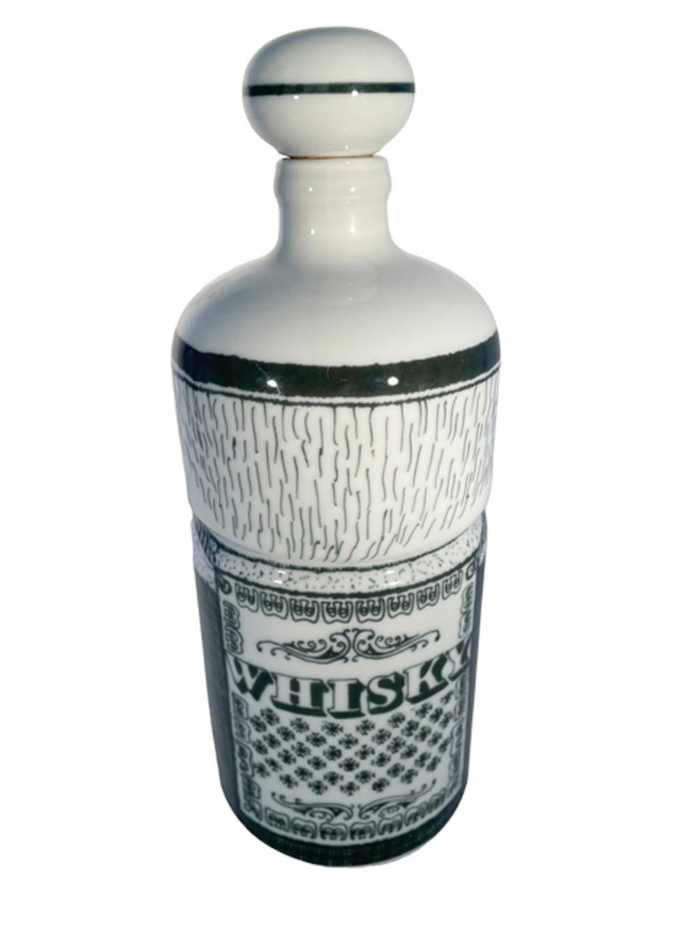 Porcelain decanter or bar bottle of cylindrical form with domed top having a ball-form porcelain and cork stopper. Decorated in underglaze green as a 'barman' wearing a sandwich board with the word 