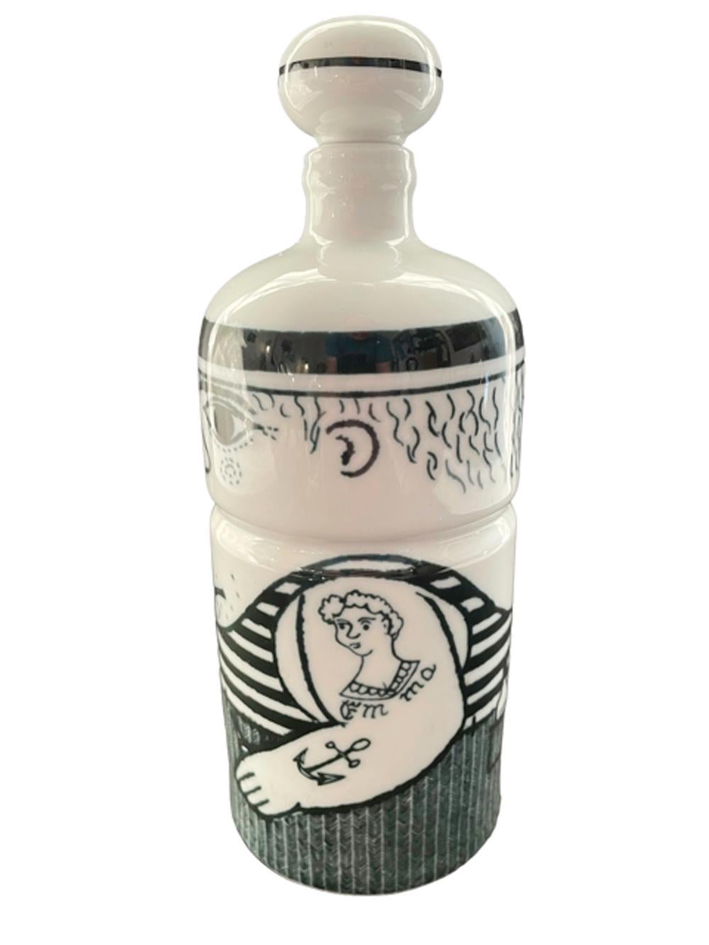 Porcelain decanter or bar bottle of cylindrical form with domed top having a ball-form porcelain and cork stopper. Decorated in underglaze blue as a sailor with tattooed forearms and biceps, holding a pipe in one hand and with his other thumb hooked