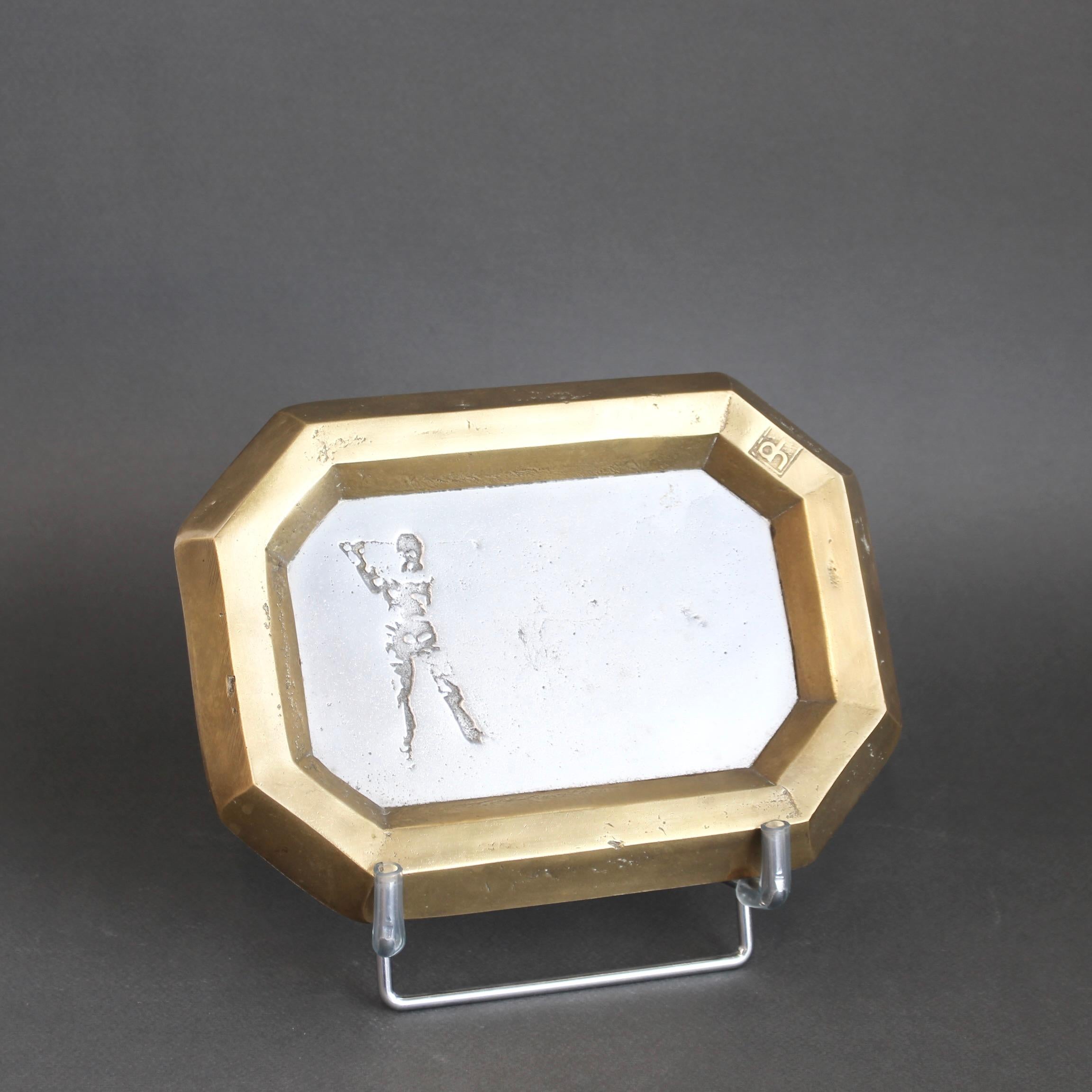 Un vide-poche en aluminium et laiton (vers les années 1980) de David Marshall est lourd pour sa taille et merveilleusement tactile avec la marque du fabricant imprimée sur la surface en laiton de style brutaliste. Le profil d'un golfeur en plein