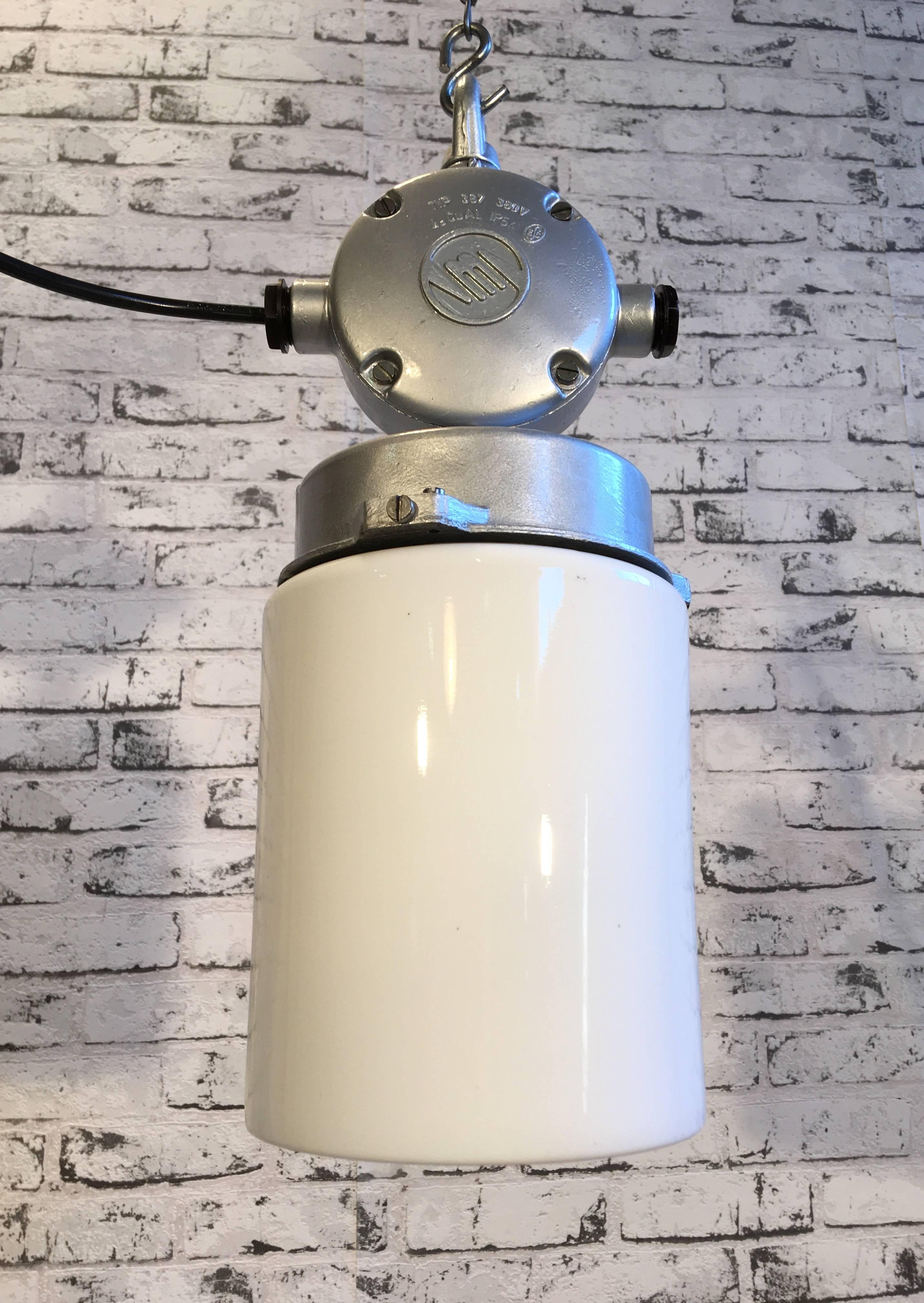 This industrial lamp in aluminium with milk glass was produced durig the 1970s in former Czechoslovakia. It features a cast aluminium top and milk glass. New porcelain socket for E 27 lightbulbs and wire. Weight of the lamp is 2 kg.