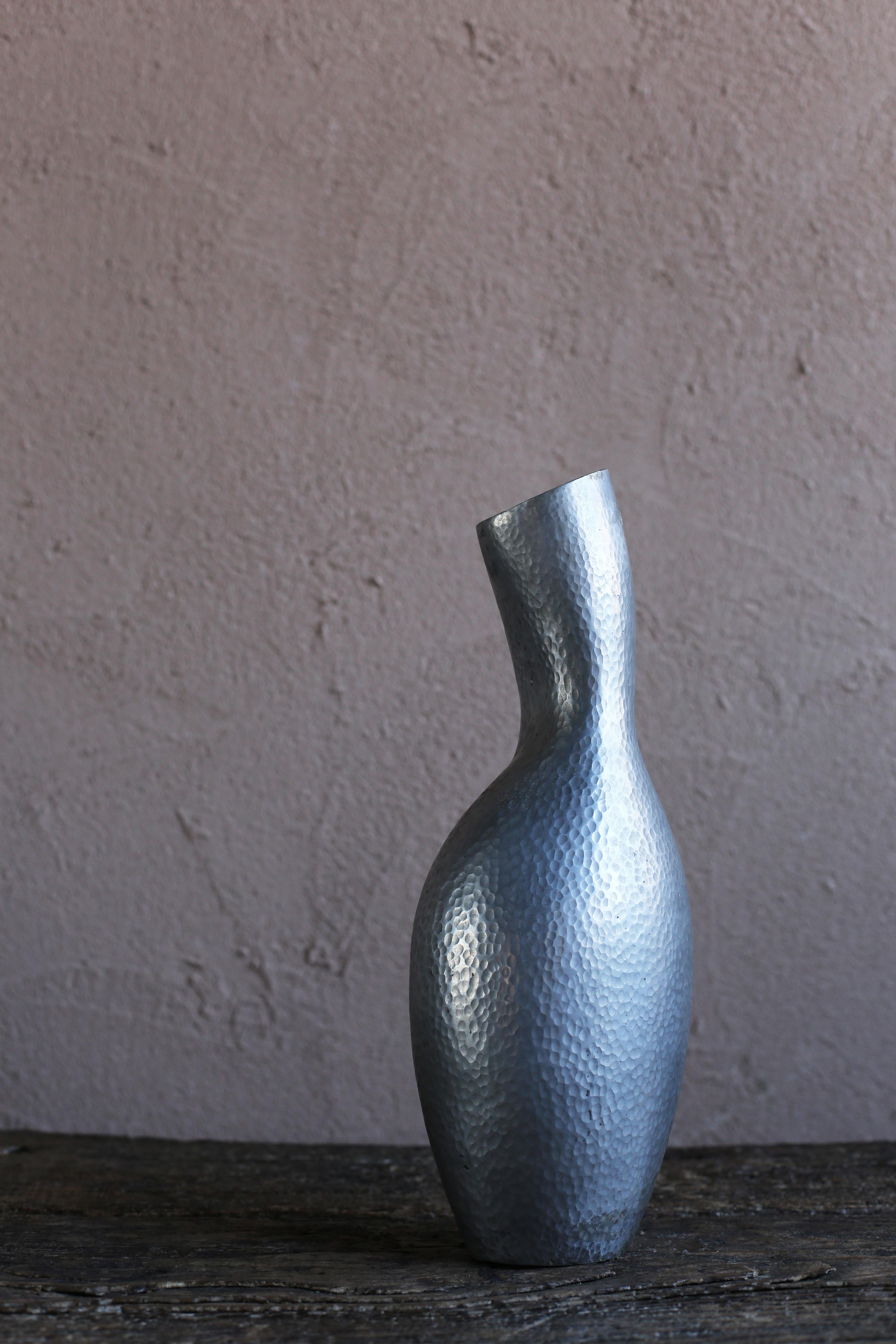 A vintage vase by a Moroccan artist. The artist is unknown. Made of cast aluminum with a unique shape. The texture of the texture that seems to be finely tapped is also interesting.
