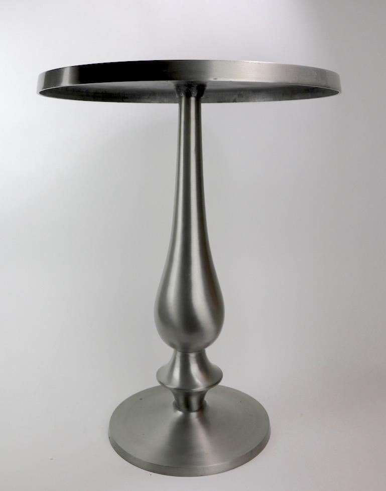 Chic side, or end table in solid aluminum having disk top on balustrade pedestal base. Top shows some cosmetic wear and oxidation, normal and consistent with age.