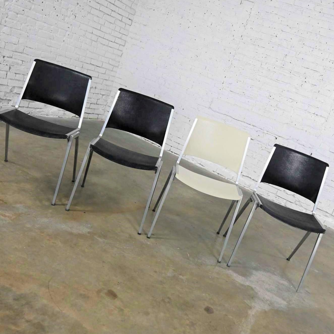 Gorgeous vintage steelcase stacking chairs model #1278 1 white & 1 black set of 4. Great Mid-century modern industrial look. Comprised of extruded aluminum frames and molded plastic seat and backs. Beautiful condition, keeping in mind that these are