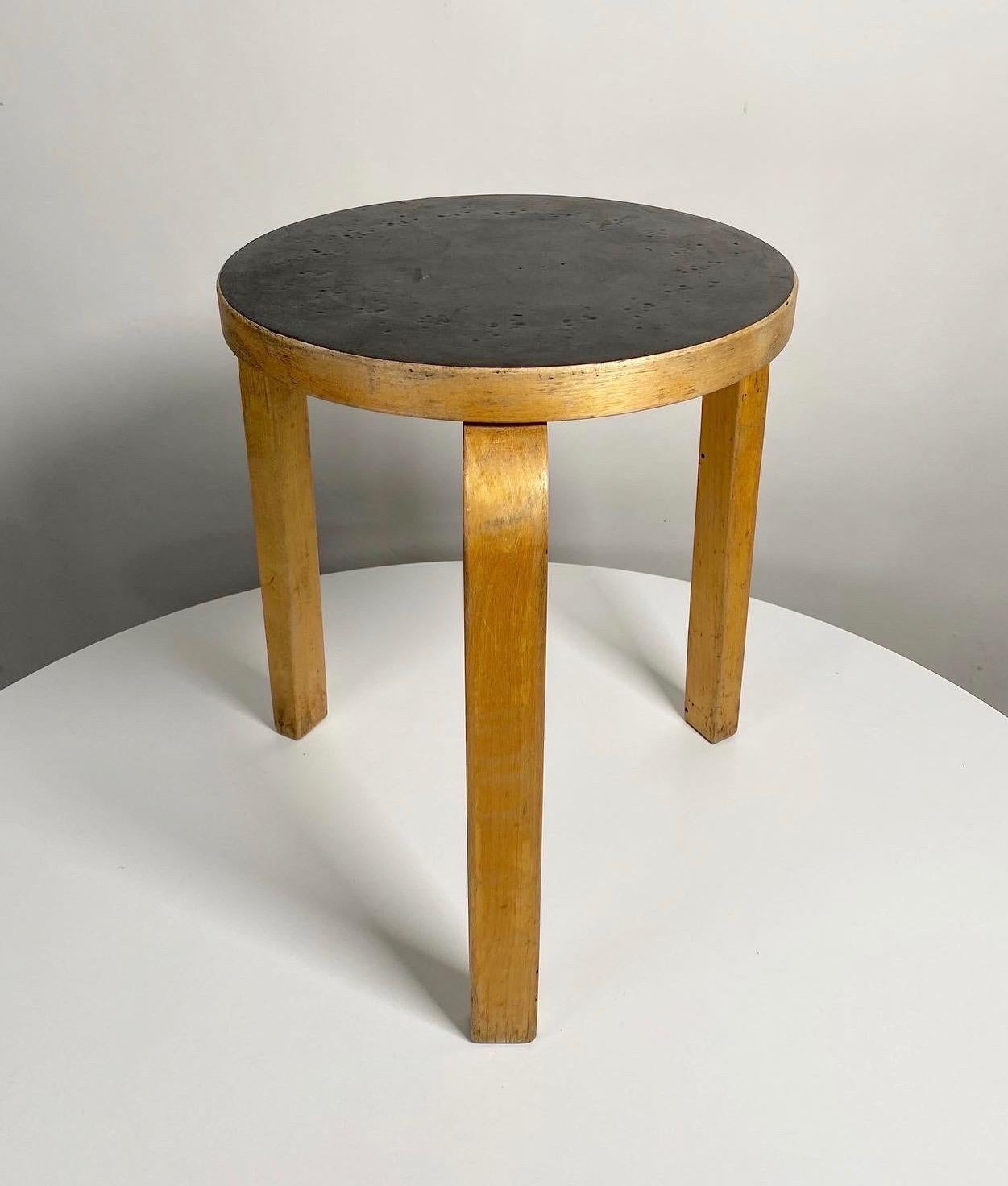 Nice earlier example, 1950s all original example of Alvar Aalto's model 60 L-Leg stool in birch and black laminate, made by Artek. This stool has a great patina from years of service to the birch and black laminate top. Created and patented by