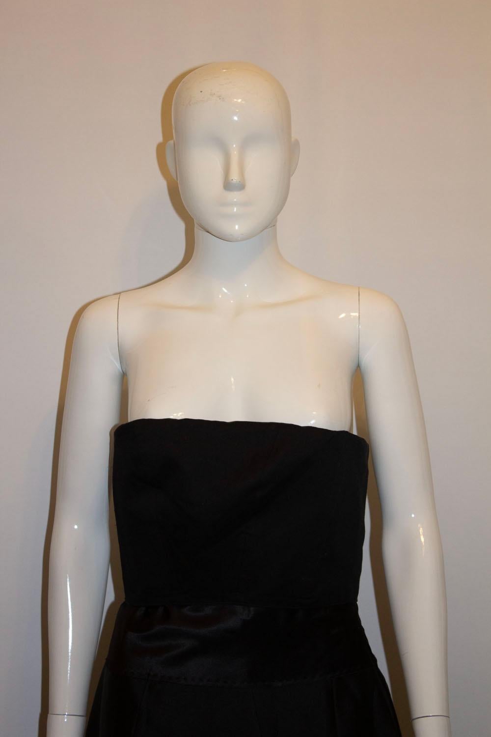 A chic vintage cocktail / dinner dress by Amanda Wakeley main  line. The outerfabric and lining are silk. It has a fold over top , and back central zip, with a pleat at the front. Shoulder straps could easily be added. UK size 12. 
Measurements: