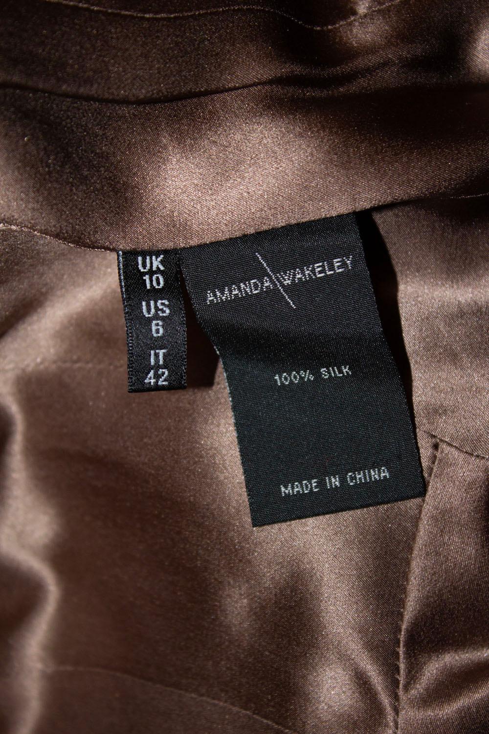 Une soie noire étonnante et facile à porter  veste vintage d'Amanda Wakeley, ligne principale.
La veste est superbement taillée, avec un col découpé et une ceinture à nouer. Il est doublé de soie.
Taille 10. Les mesures doivent aller jusqu'à