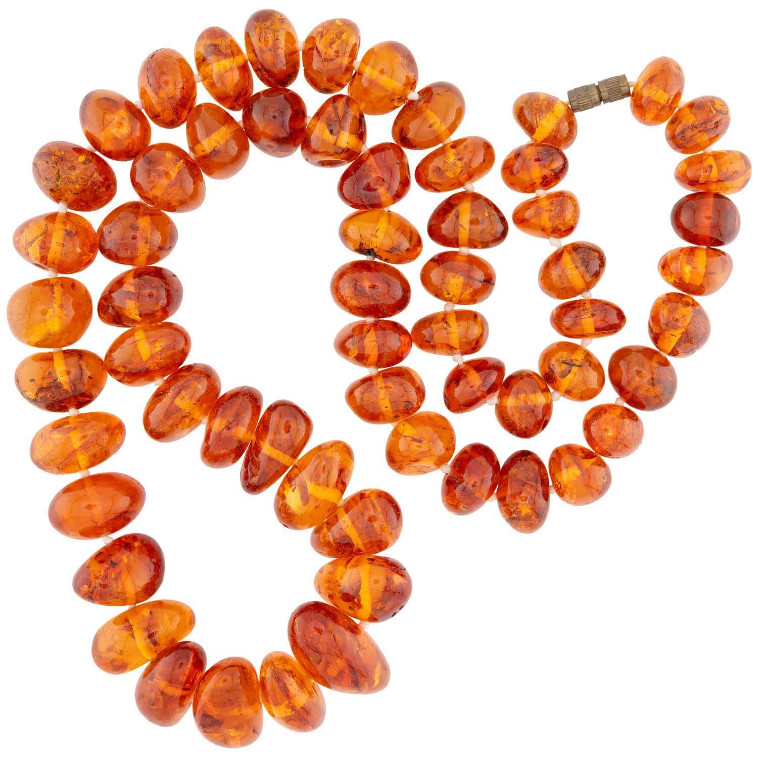 A fabulous strand of Baltic amber beads from the Vintage (ca1950s) era! This wonderful necklace is comprised of amber beads, which are hand-strung on white thread and vary in shape and size. The beads display a lovely deep orange hue, and feature