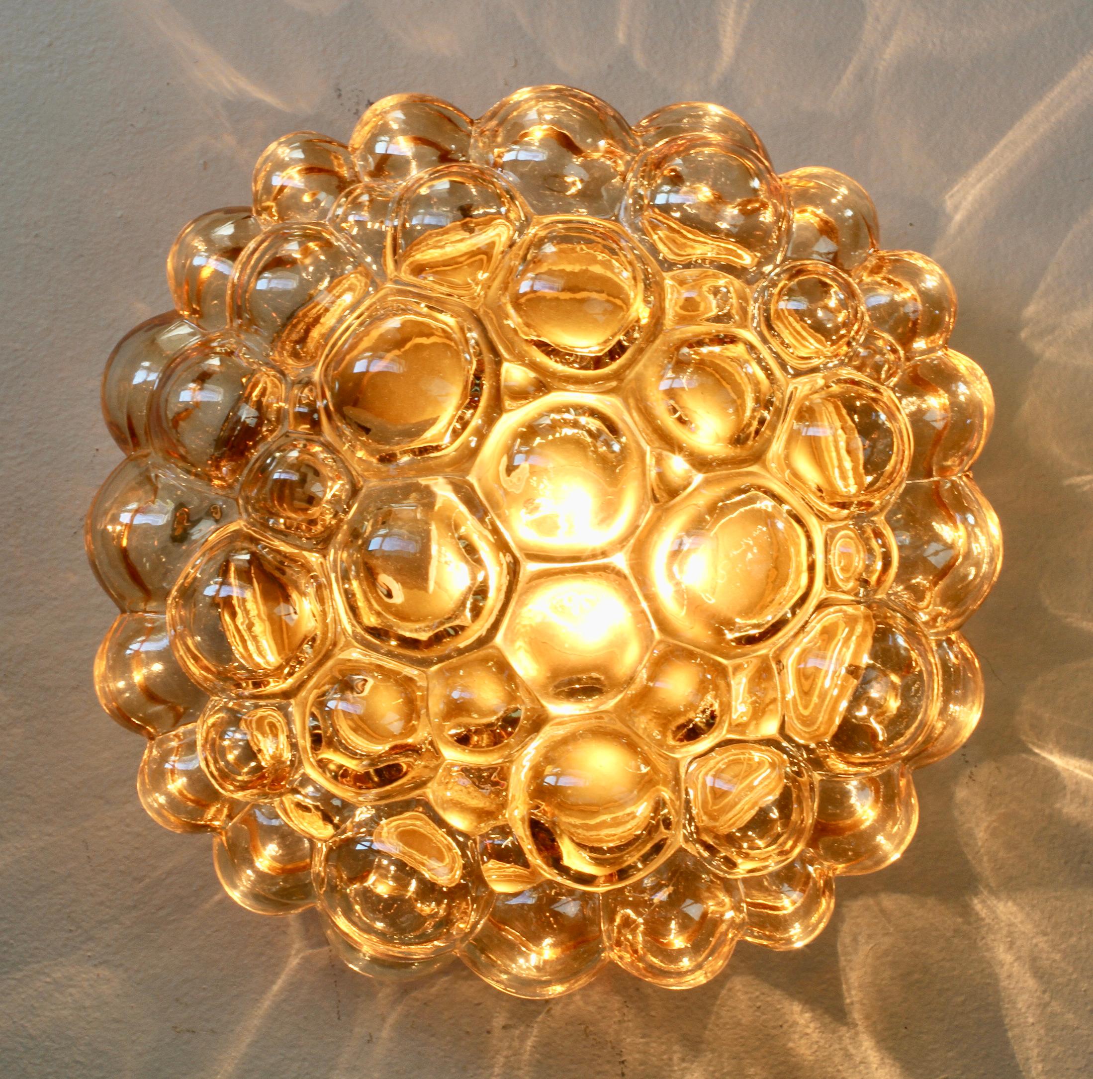  Mid-Century bubble glass wall or ceiling flush mount wall or ceiling light attributed to Finnish glass designer Helena Tynell for Glashütte Limburg, Germany, circa 1960. The glass has a subtle amber / champagne color (colour) and sits within a gold