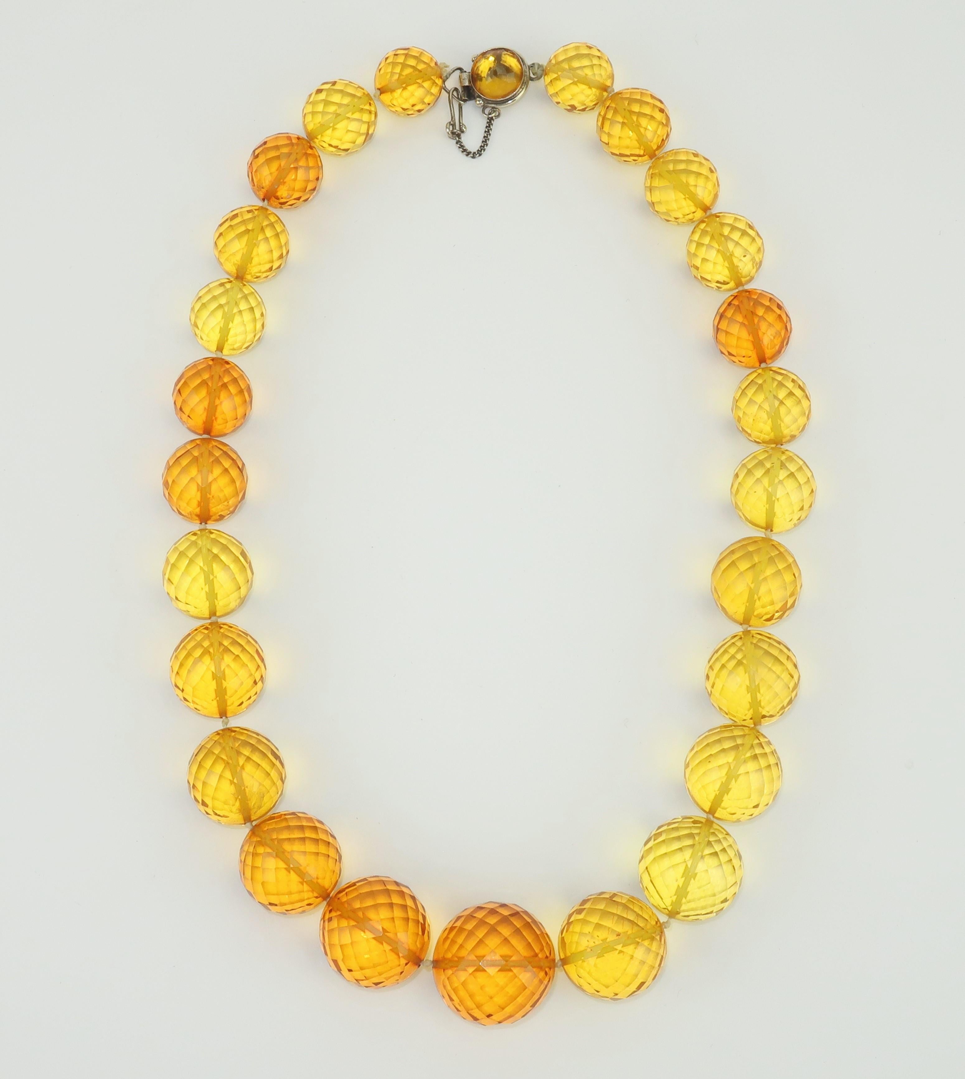 Vintage amber faceted acrylic bead necklace with a sterling silver clasp closure.  The faceted beads are graduated in size and offer a wonderful glow with a semi-transparent appearance.  The sterling silver slide clasp has an unusual safety hook and