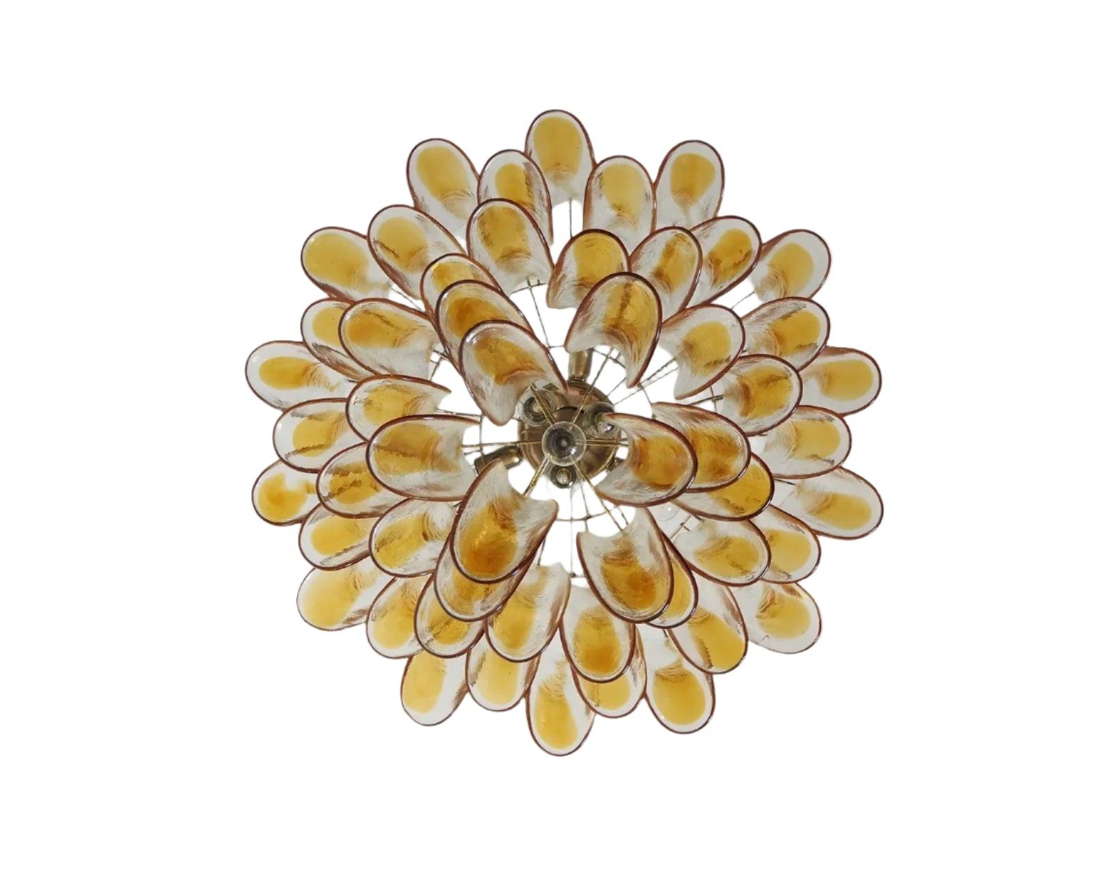 VINTAGE AMBER GLASS PETAL CHANDELIER
This Vintage Murano glass chandelier features hand-blown glass leaves in warm amber and clear tones, layered in a cascading formation that catches light like liquid gold. Its sculptural silhouette delivers both